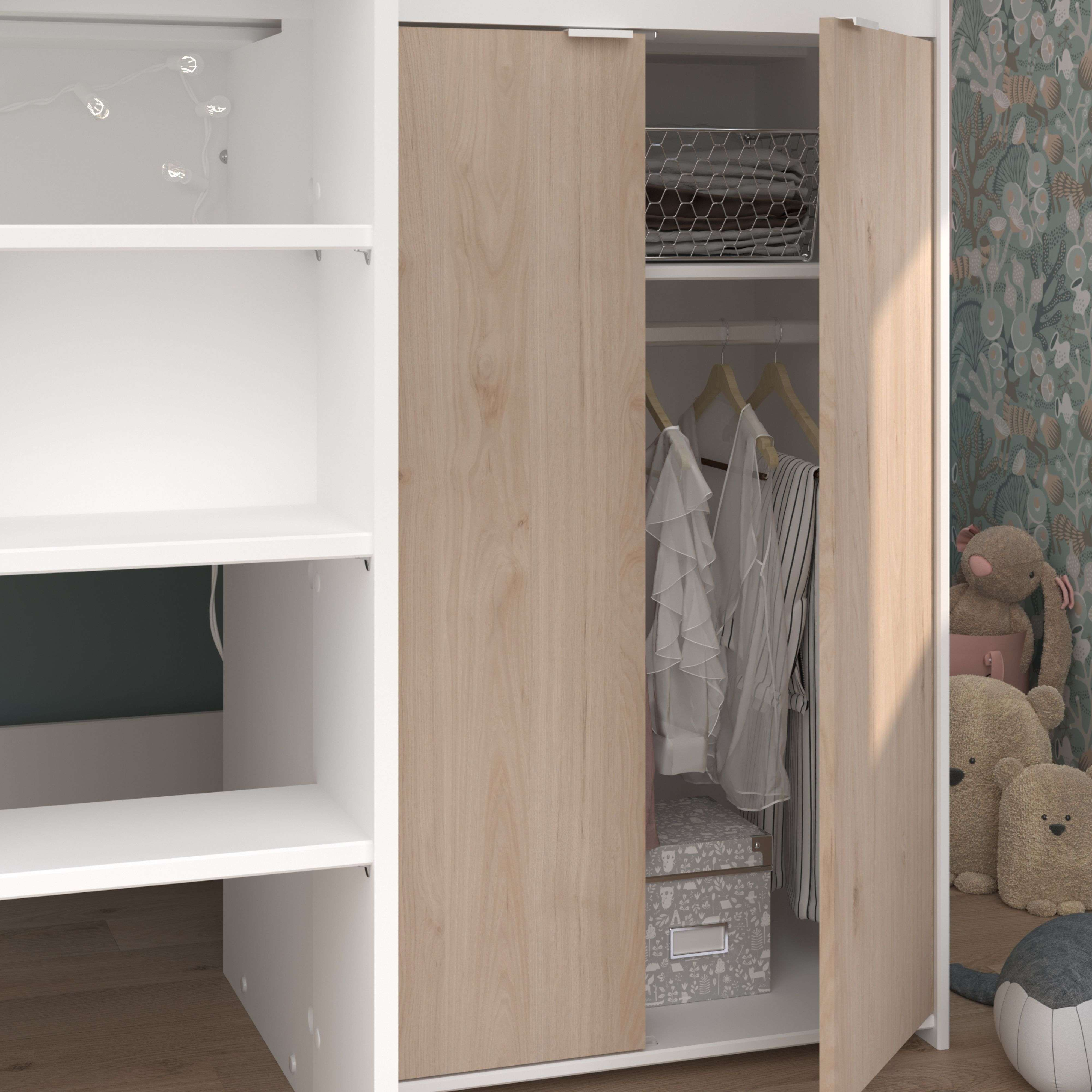 Un armario abierto con ropa, juguetes y decoración sobre suelo de madera.