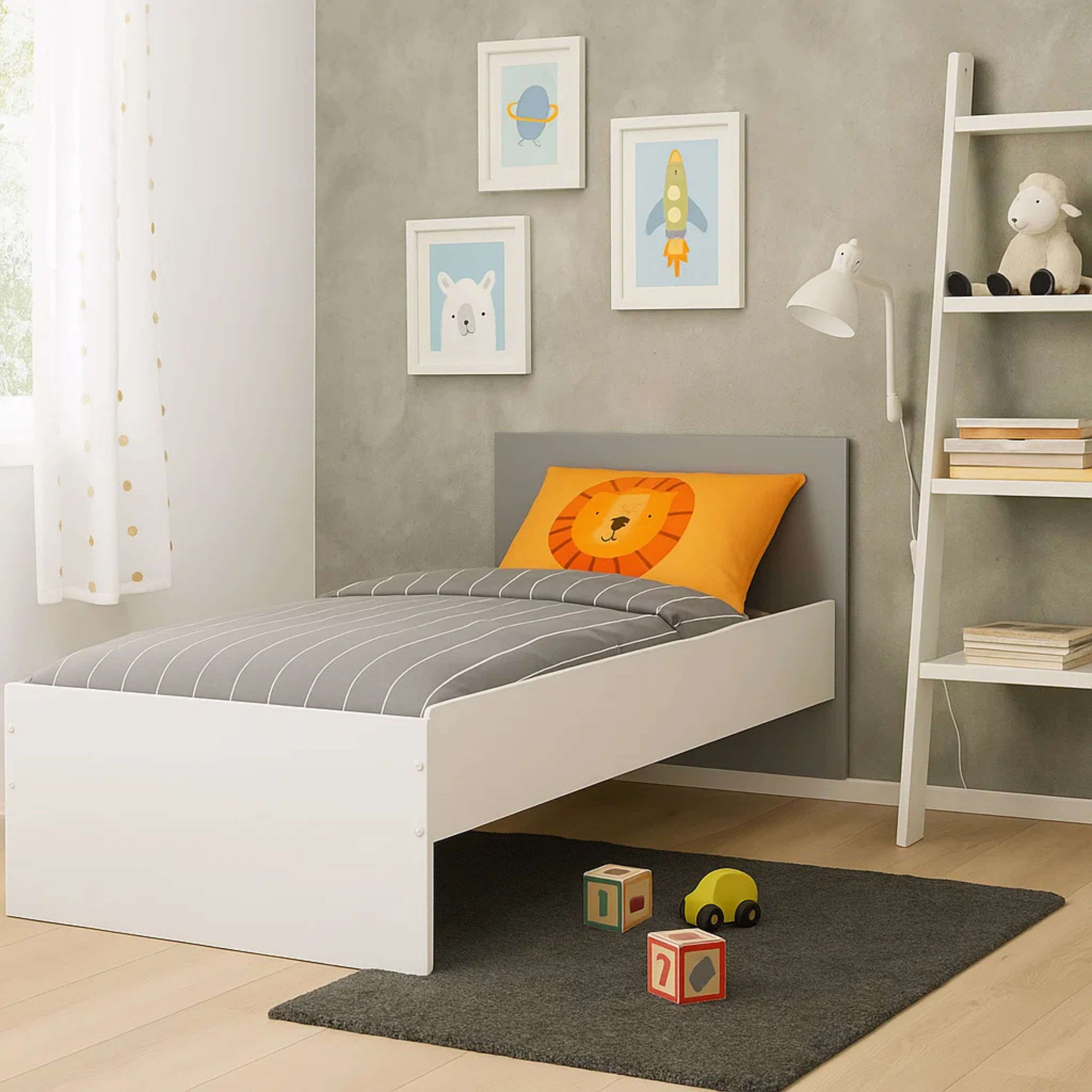 Dormitorio infantil con cama blanca, bloques de juguete y estantería.