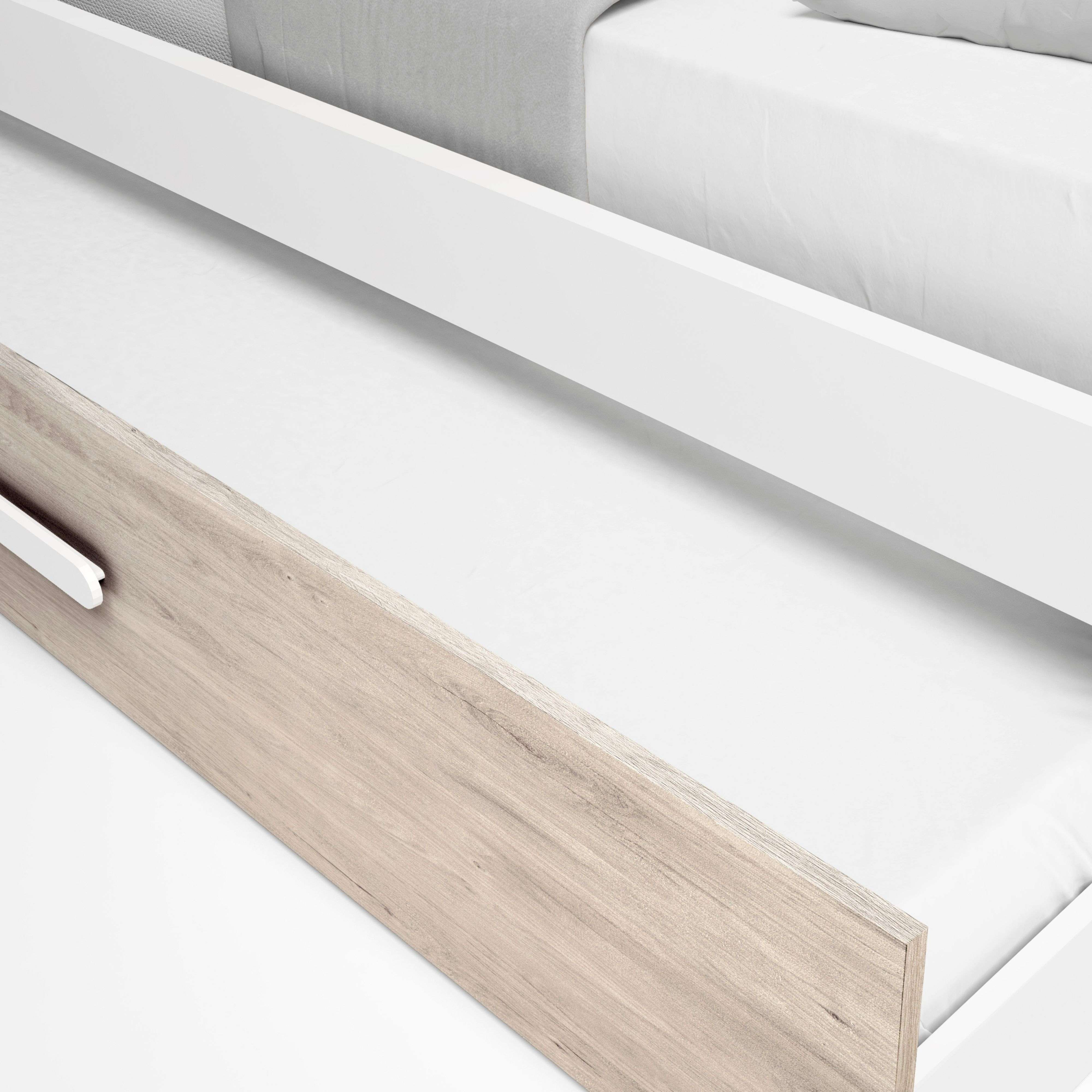 Un borde blanco de cama con veta de madera a la izquierda y ropa de cama blanca.