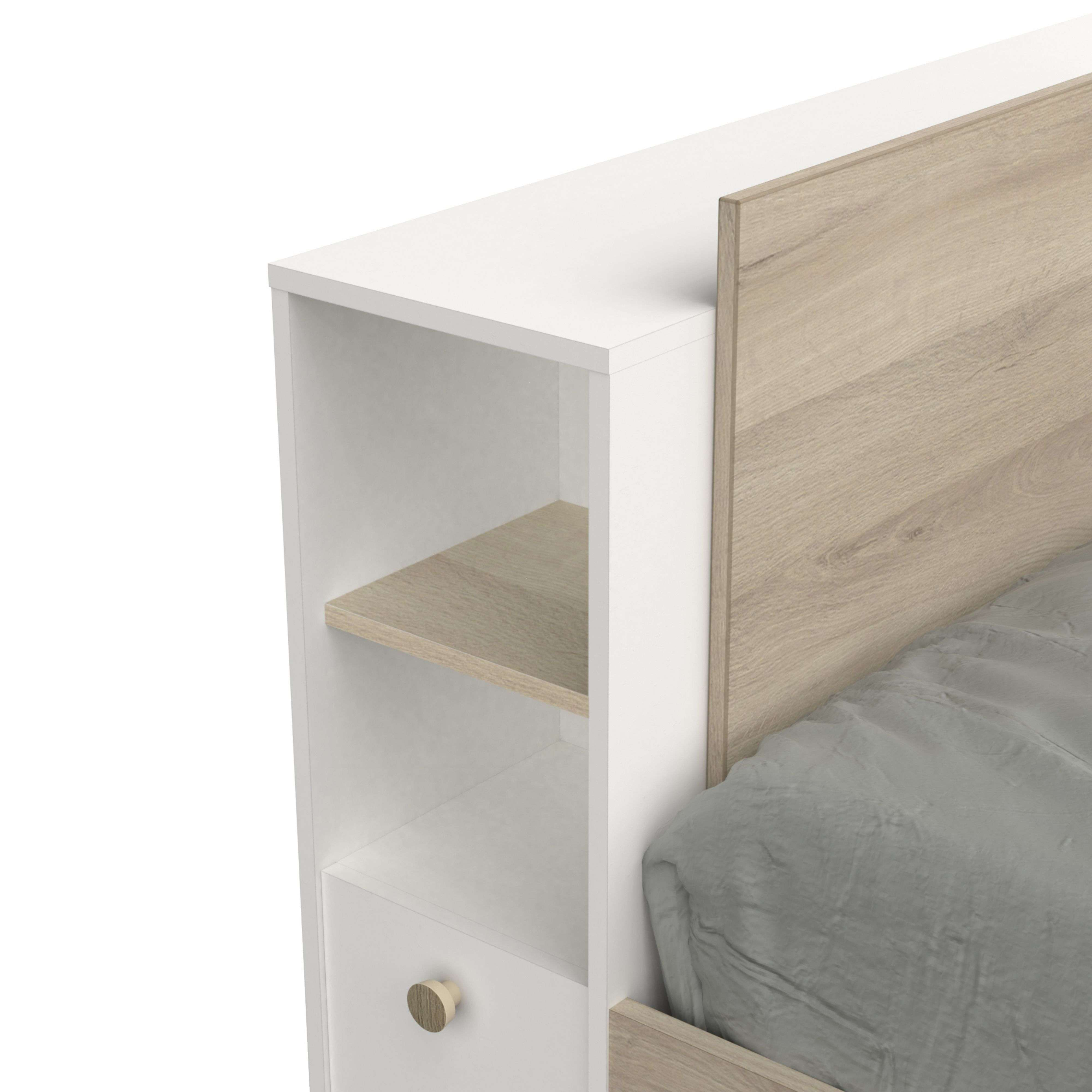 Una cama blanca con detalles en madera y un edredón gris.
