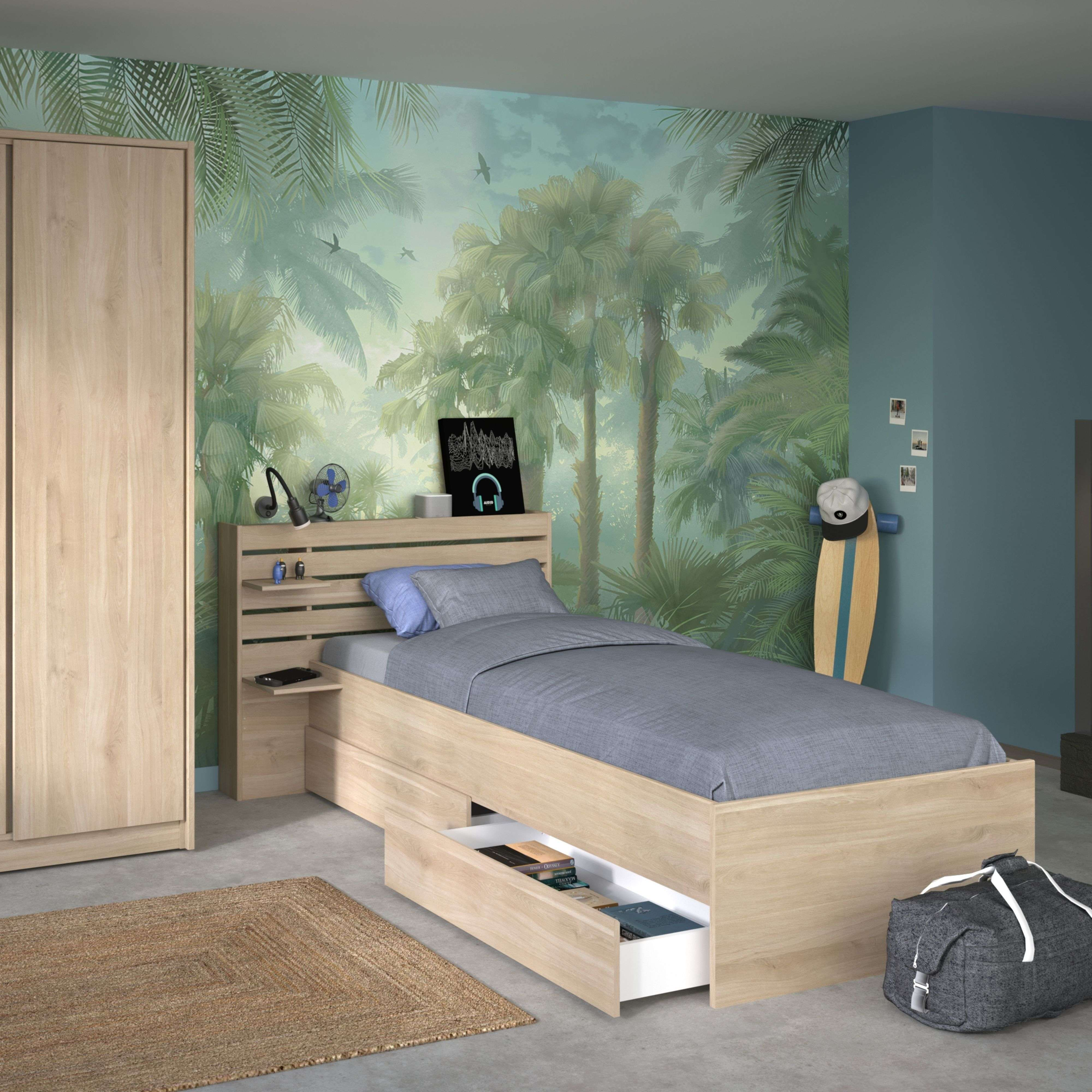 Habitación juvenil con papel pintado de selva, cama, armario y tabla de surf.