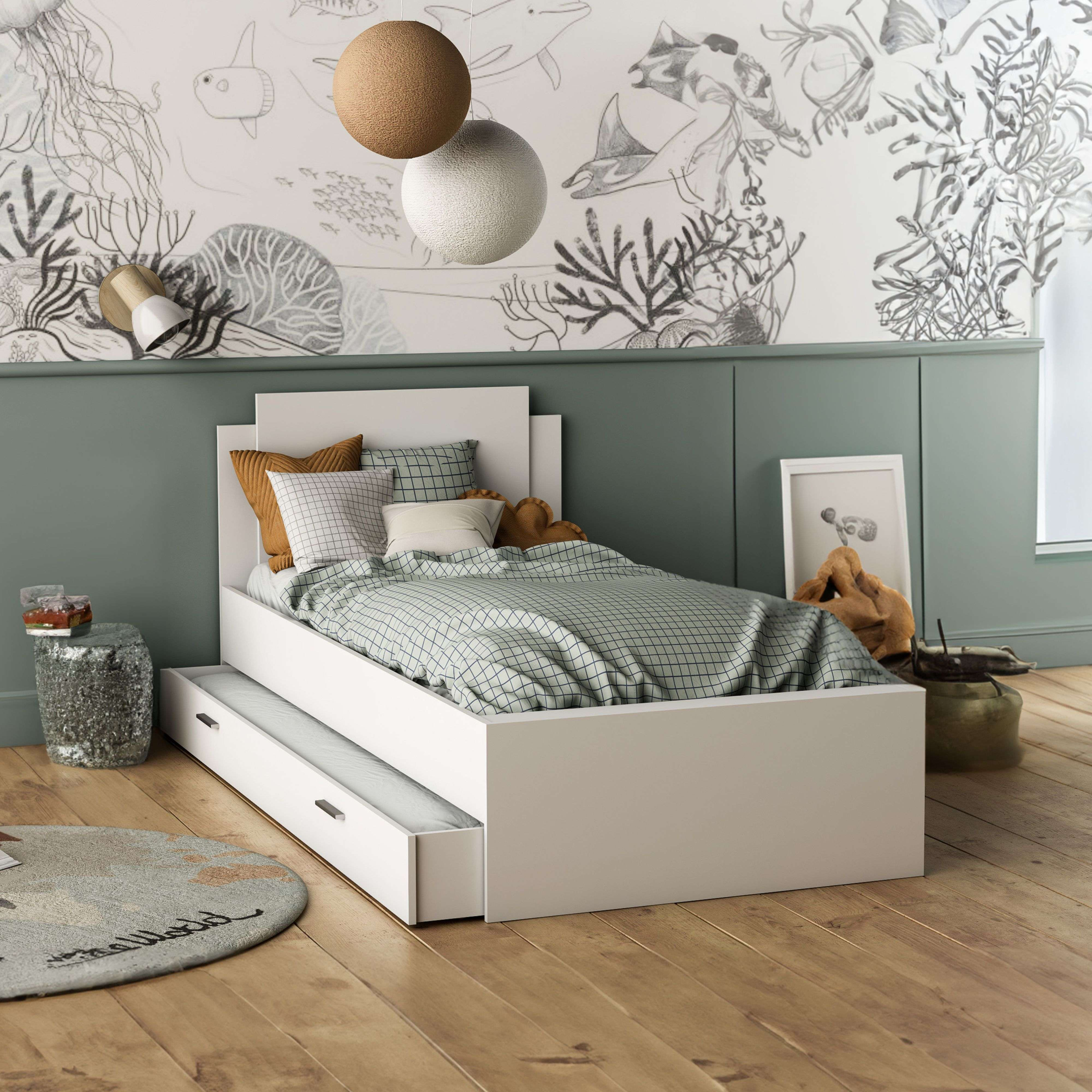 Una cama blanca con cama inferior y ropa de cama a cuadros azules contra una pared temática marina.