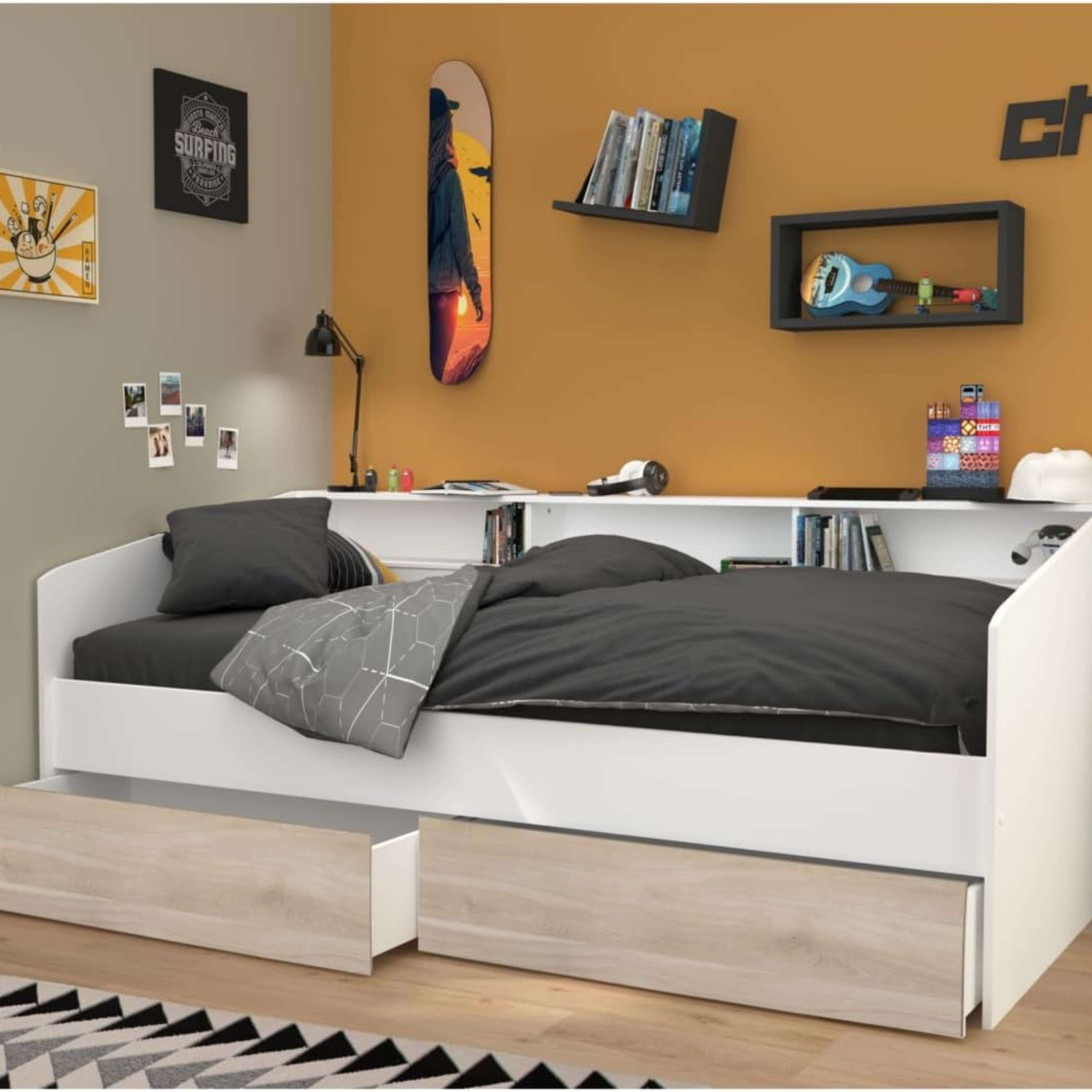 Una cama con ropa de cama oscura, cajones y decoración de pared.