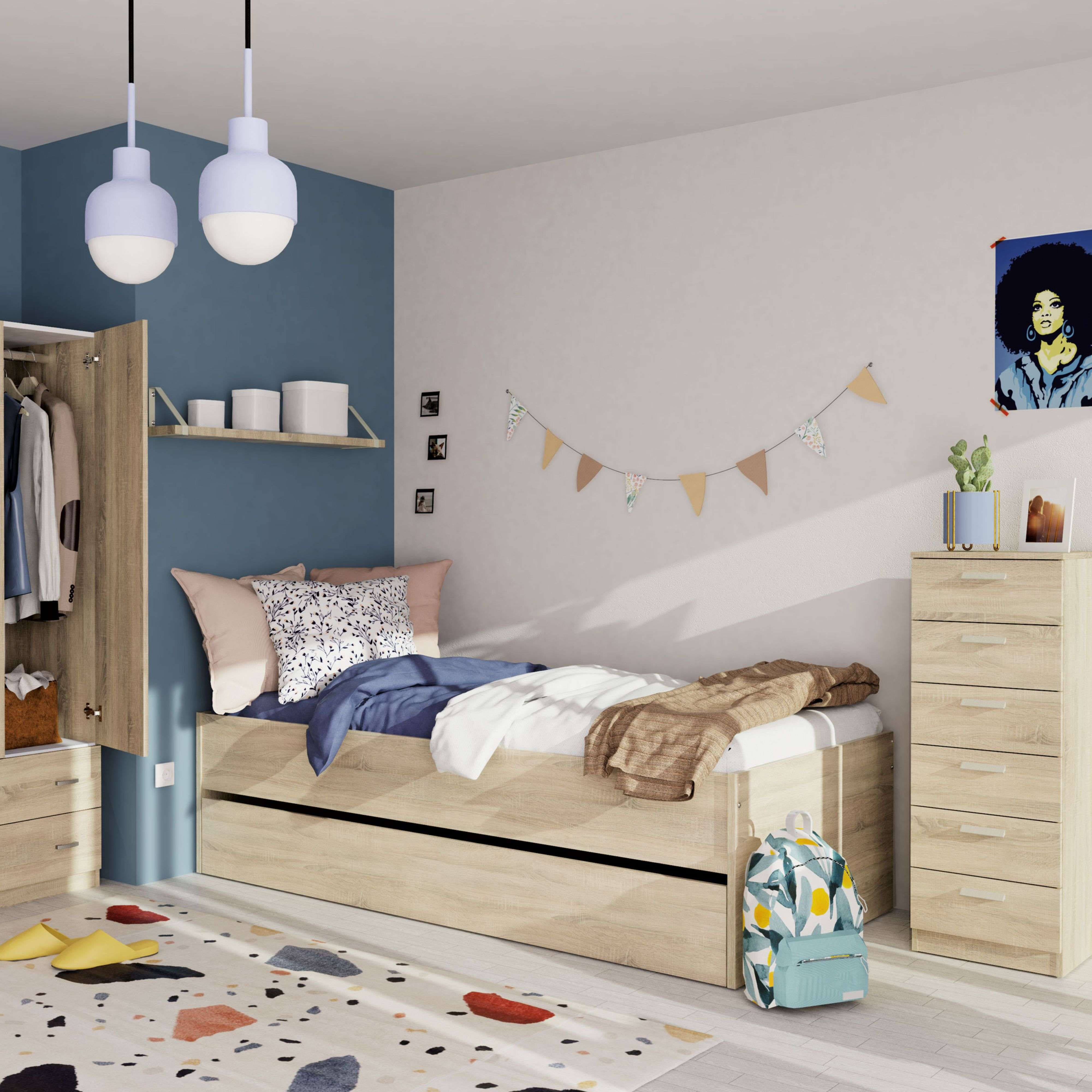Un dormitorio con cama, armario, cómoda, alfombra y mochila.