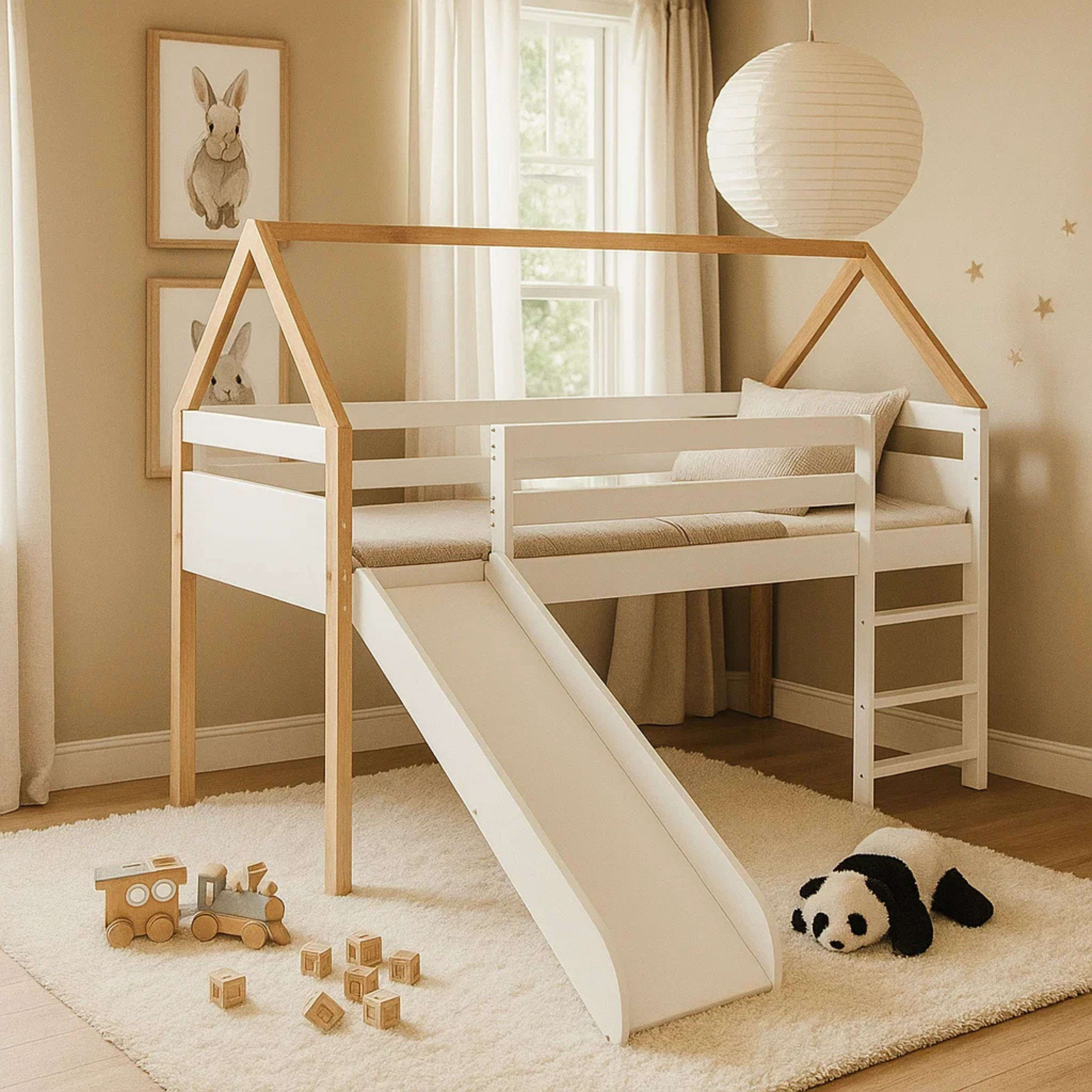 Cama alta blanca con tobogán, detalles de madera, tren de juguete y cojín de panda.