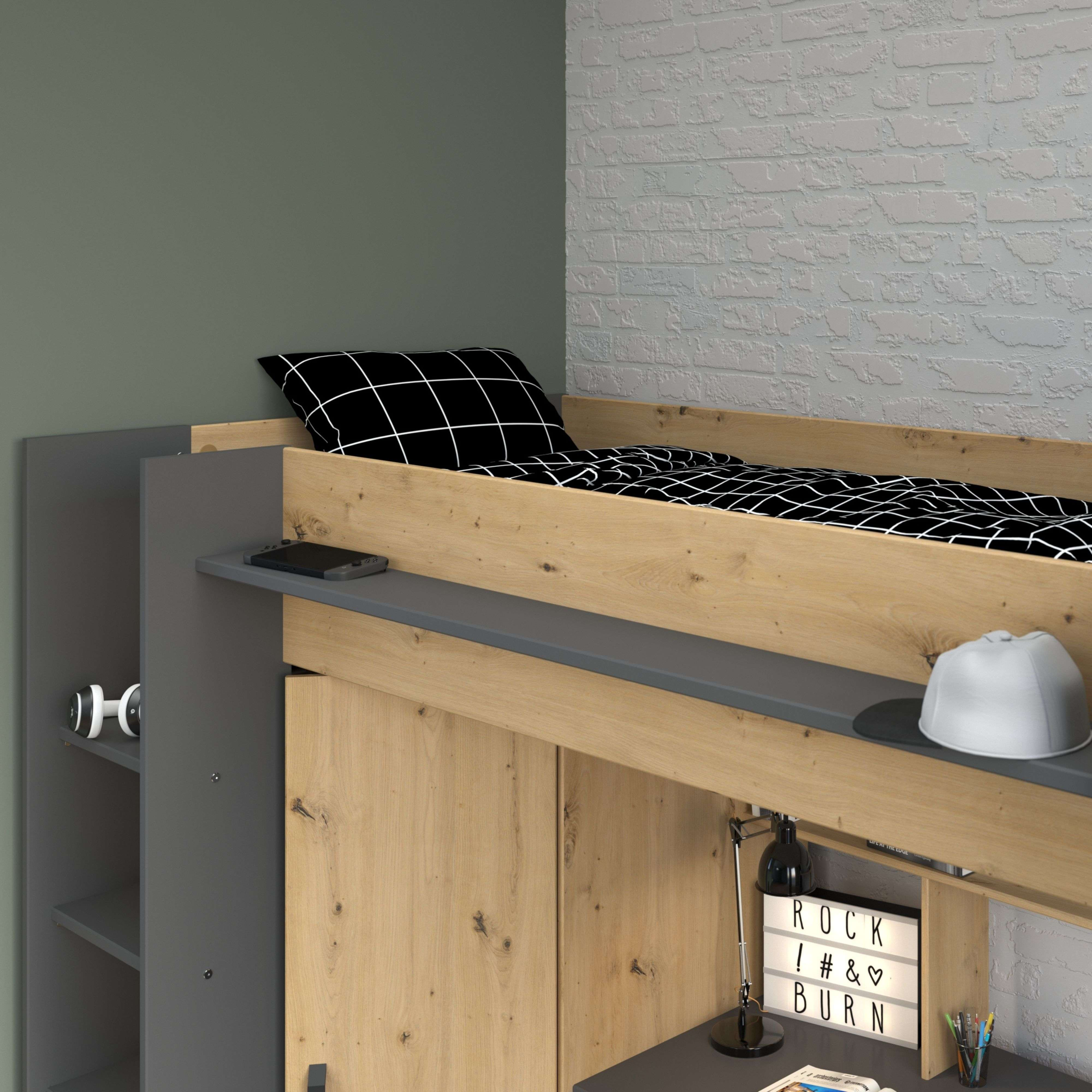 Una cama alta con ropa de cama a cuadros blancos y negros, un escritorio y un estante.