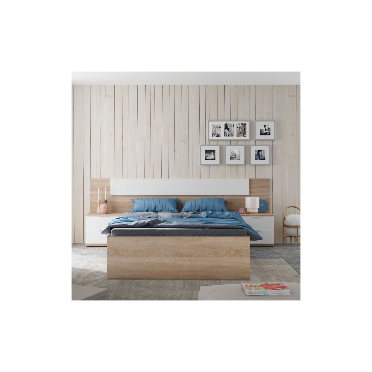 Cama de madera con almohadas azules y mesitas de noche blancas contra pared de madera.