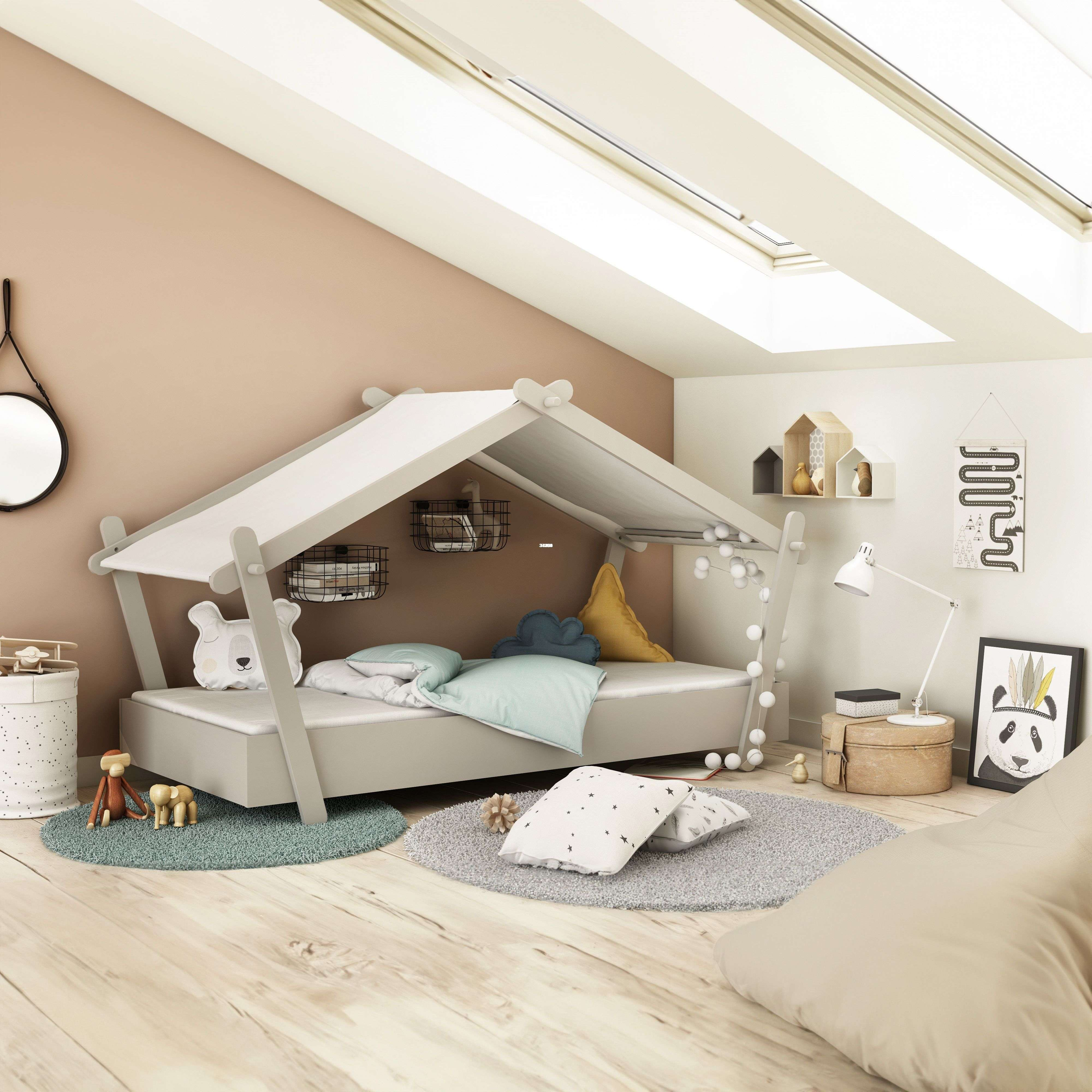 Habitación infantil con cama en forma de casa, juguetes y tragaluces.