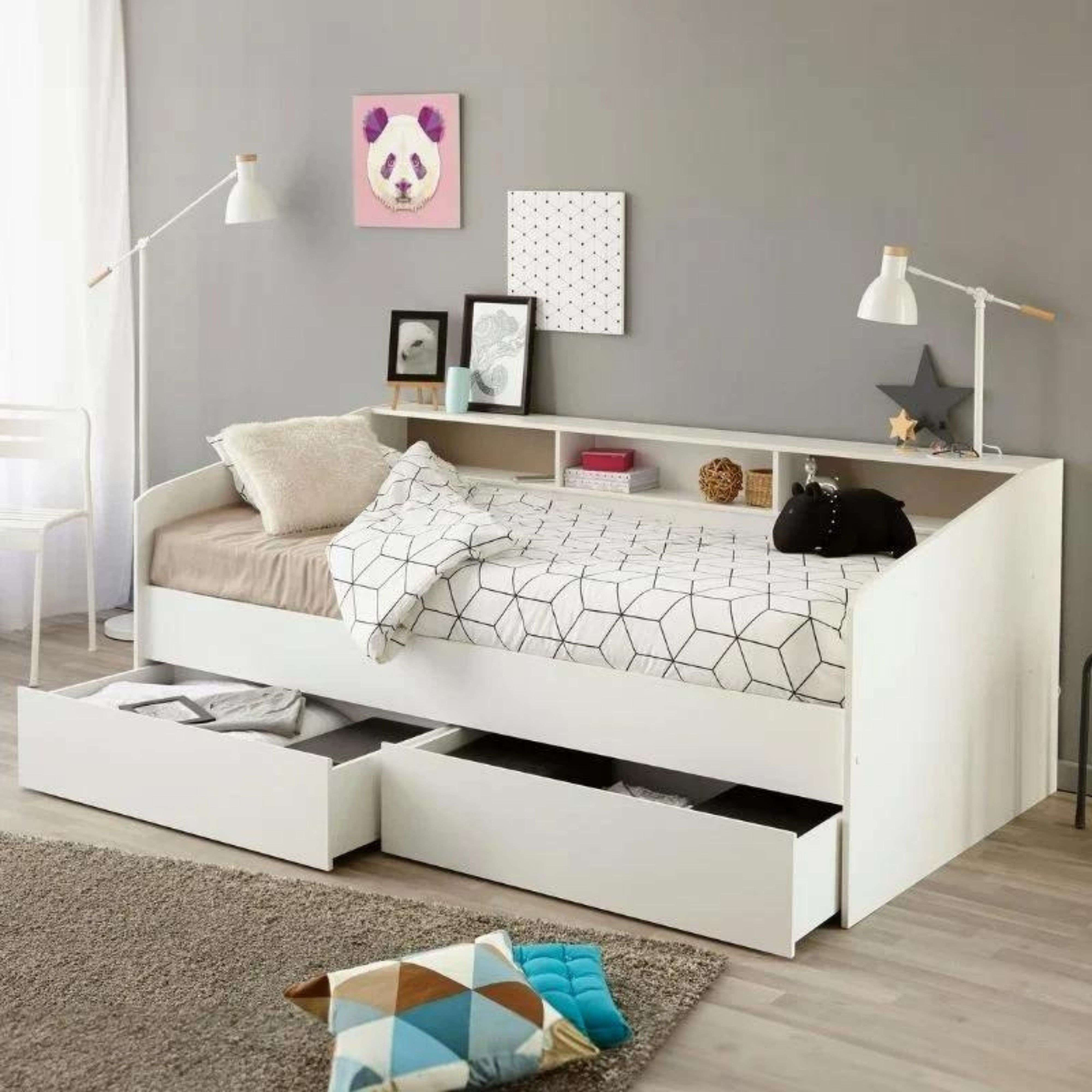 Una cama de día blanca con cajones de almacenamiento, ropa de cama geométrica y cojines.