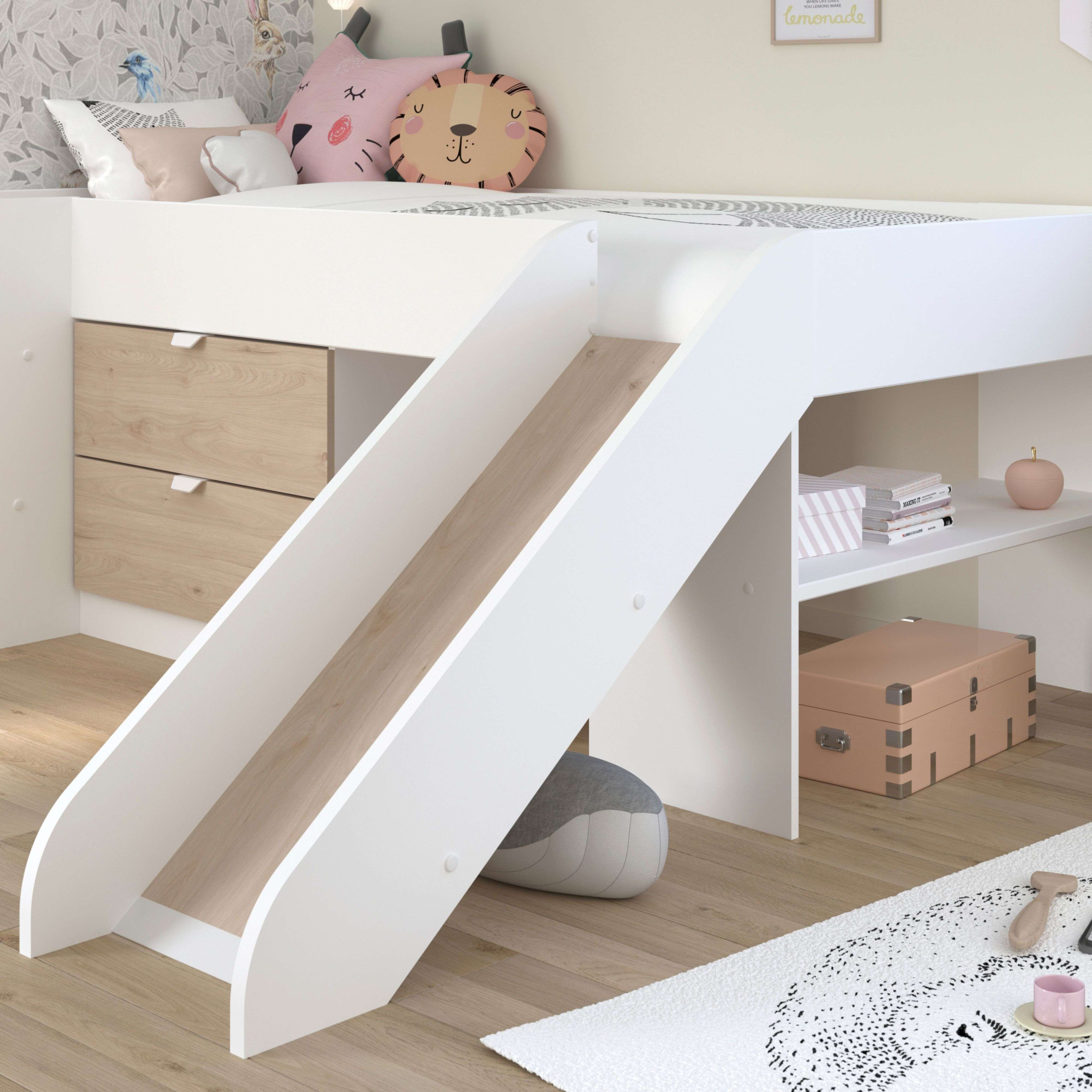 Una cama alta blanca con tobogán, cajones y estante.