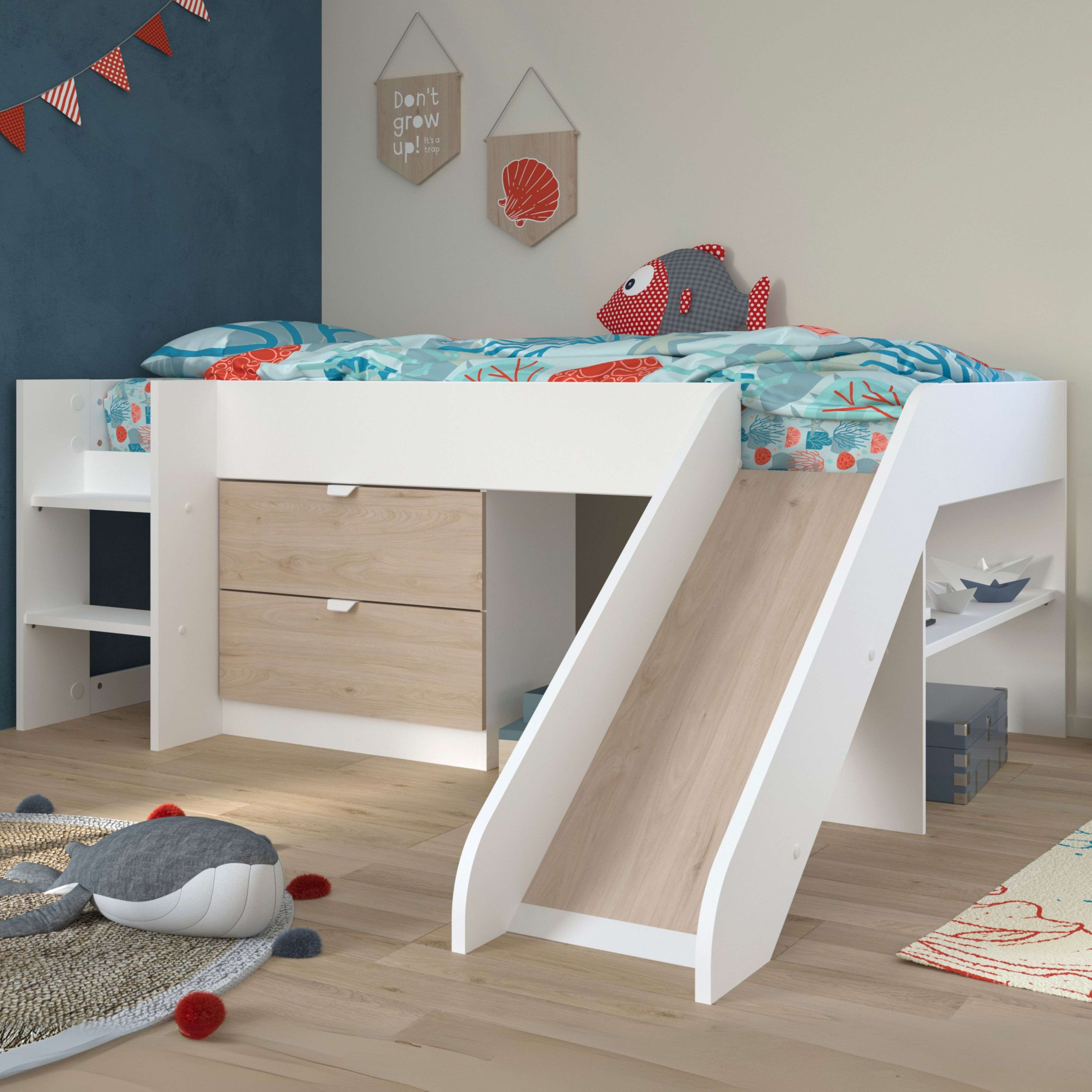 Cama alta blanca con tobogán y temática marina. Cajones y estantes debajo.