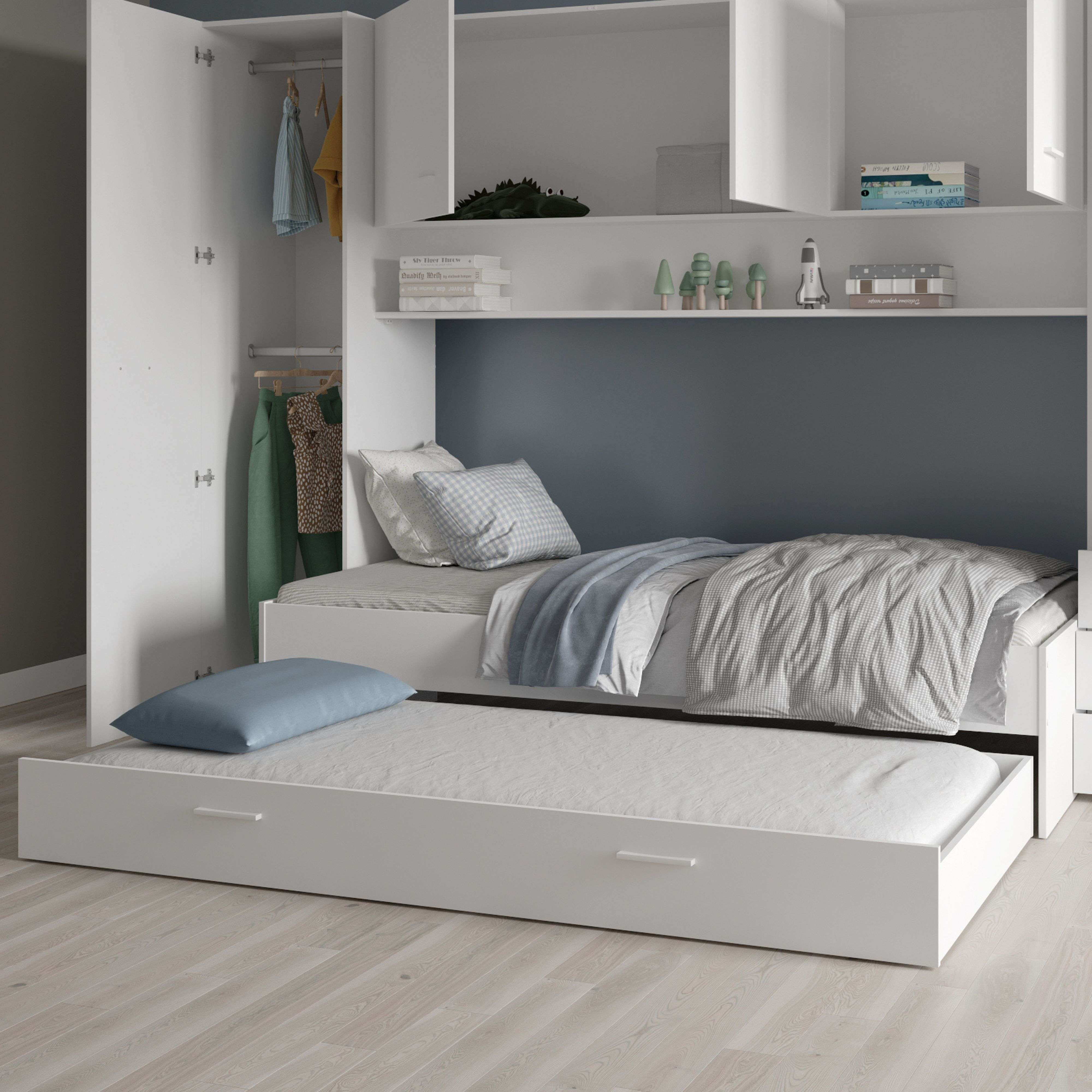 Una cama blanca con nido extraíble, armario y estante. Decorada con objetos.