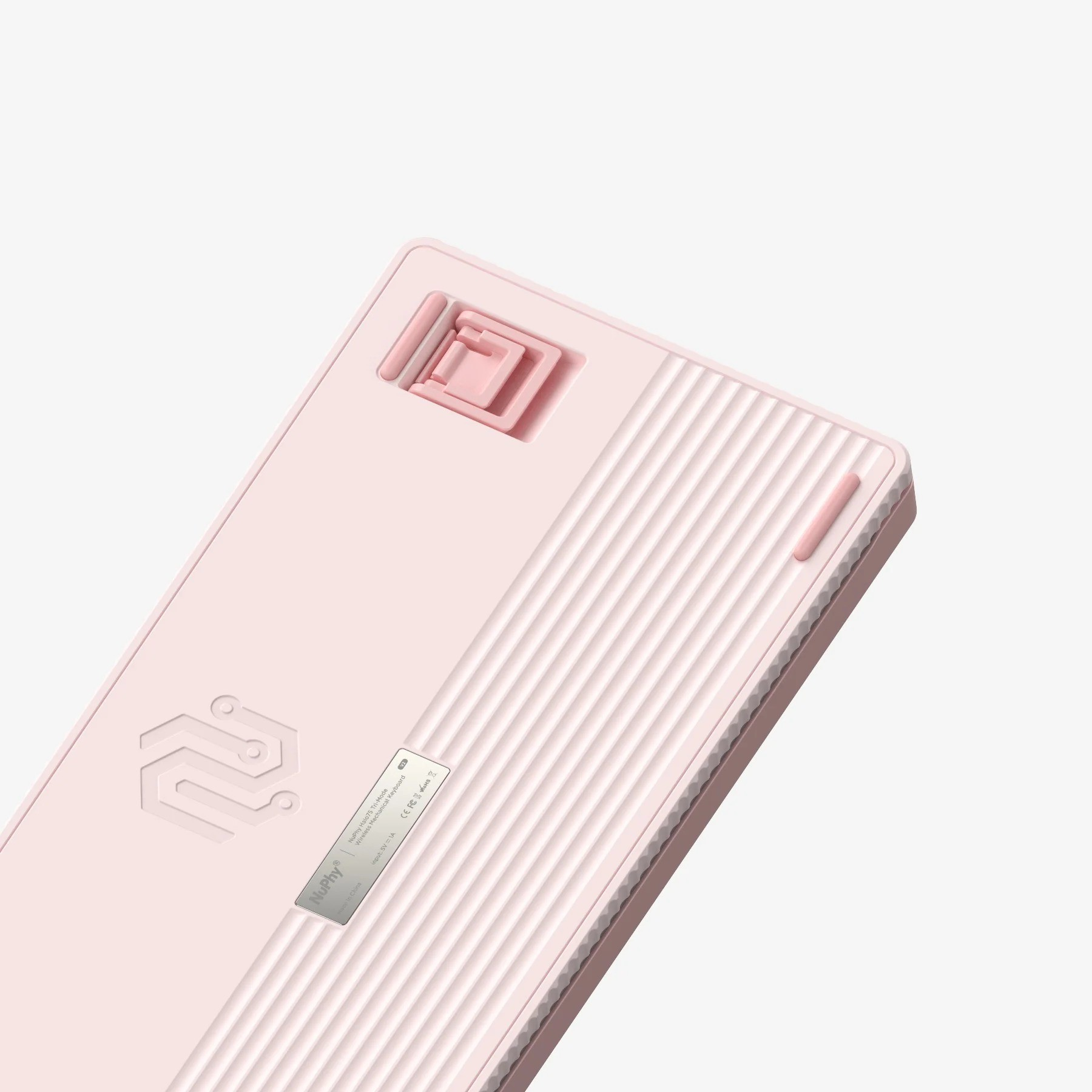 Spód jasnoróżowej klawiatury mechanicznej z rowkami i podpórką.