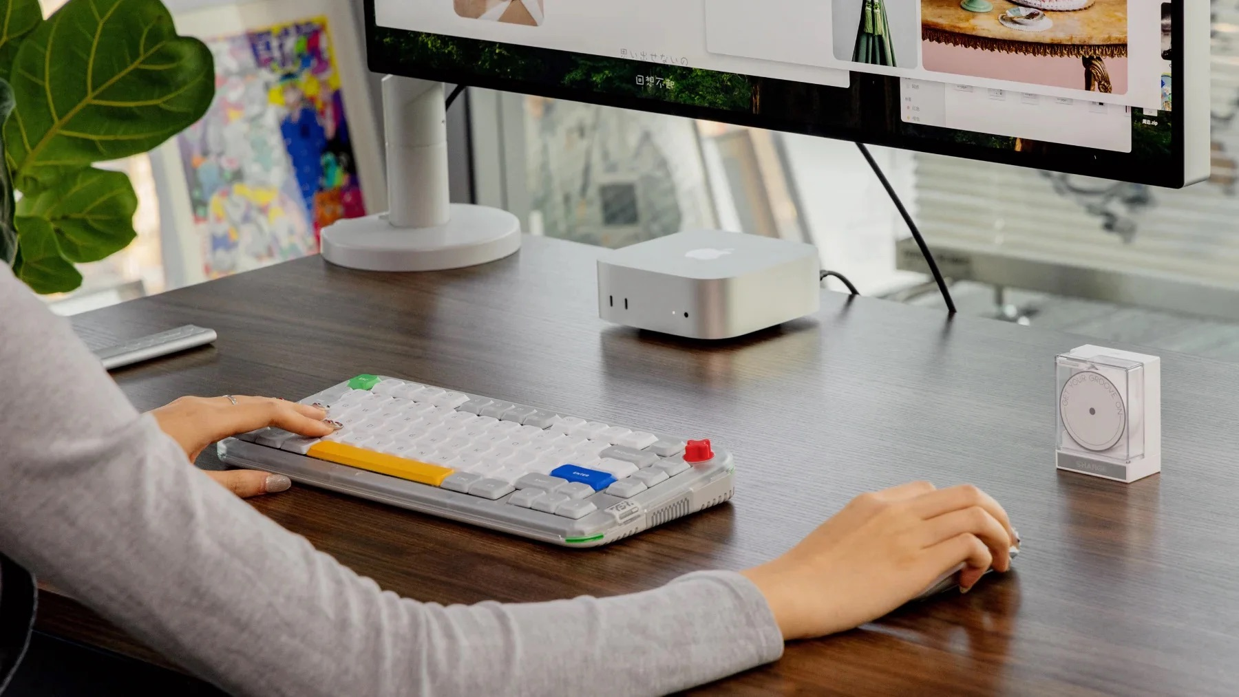 Osoba pisze na klawiaturze obok Mac Mini, myszy i małego urządzenia.