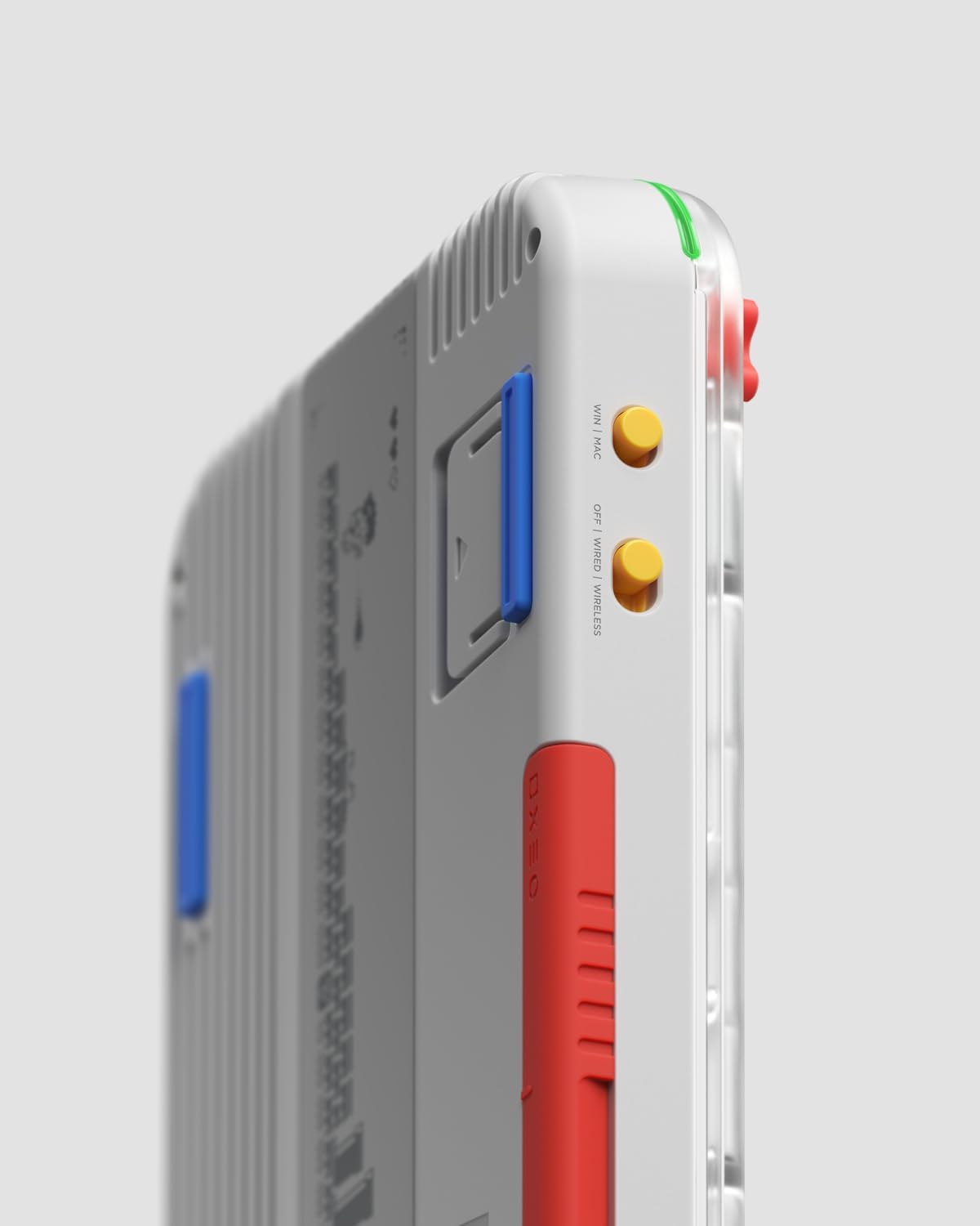 Białe urządzenie z niebieskimi i czerwonymi akcentami, przyciskami bocznymi i portem ładowania.