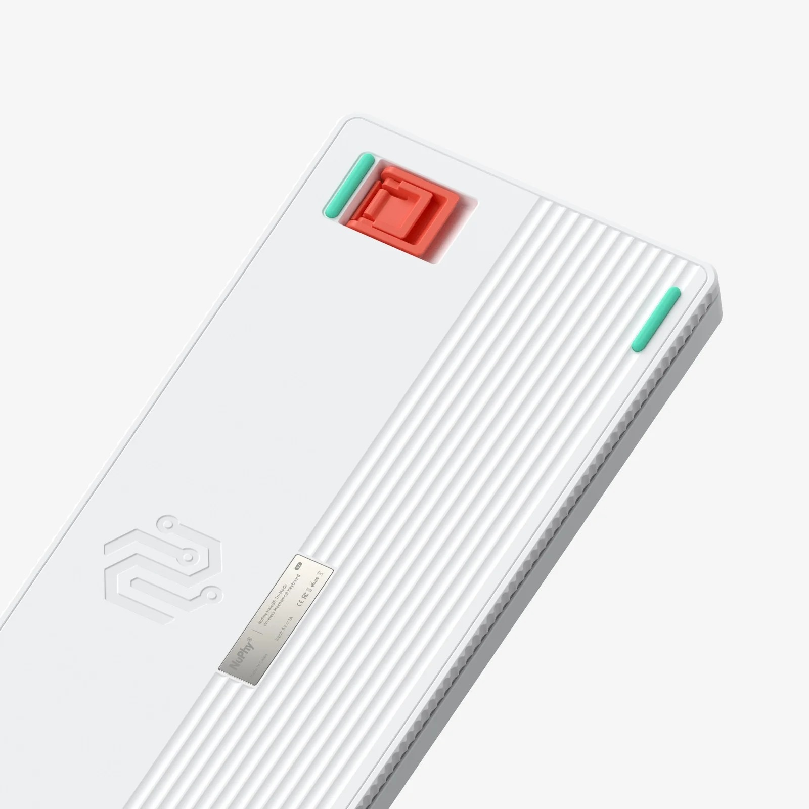 Spód białej klawiatury z czerwonymi i zielonymi akcentami oraz prążkowaną teksturą.