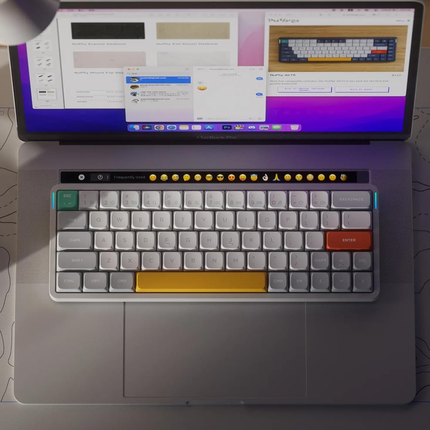 Laptop z otwartym ekranem, wyświetlający stronę internetową klawiatury i wiadomości e-mail.