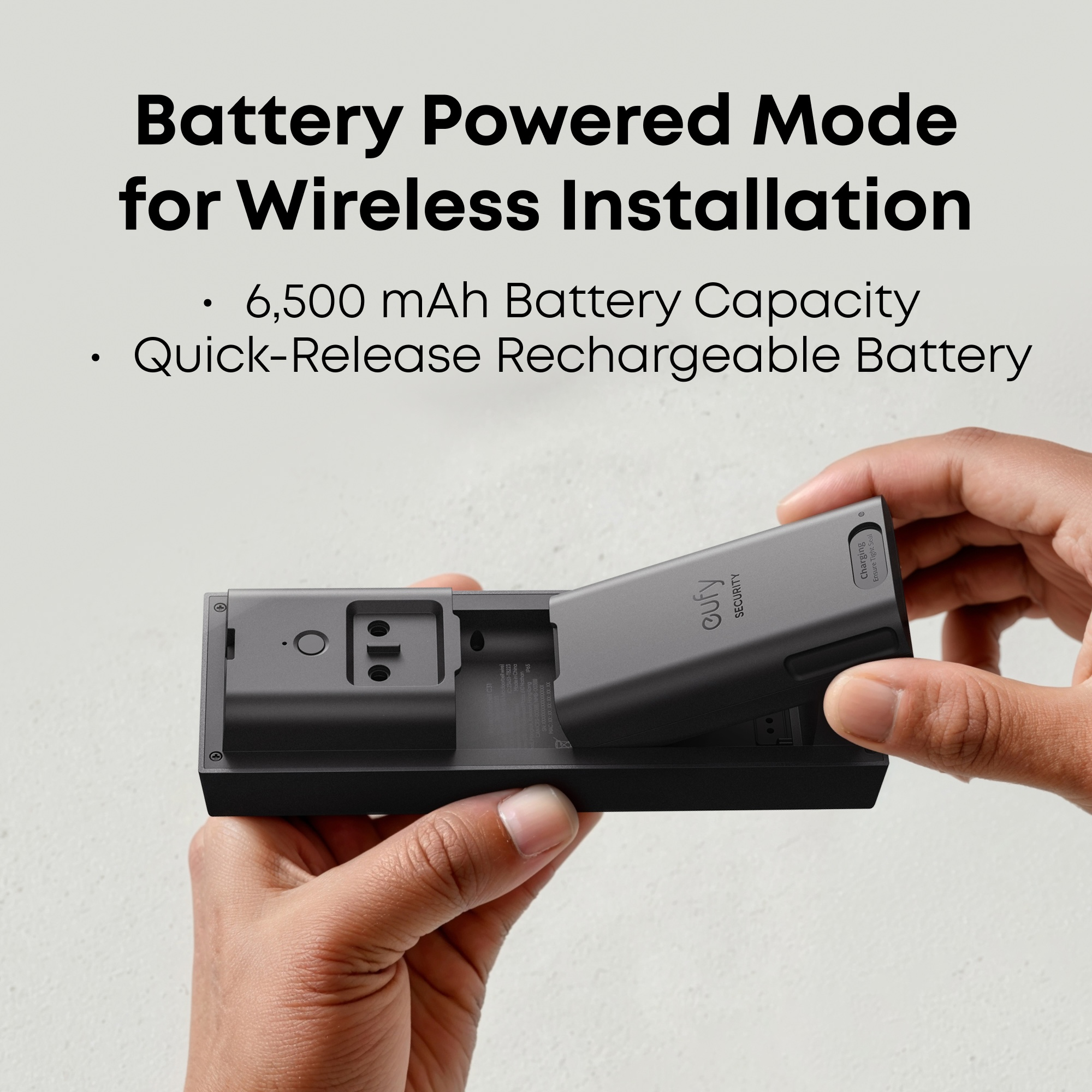Hände setzen eine graue Batterie in eine schwarze Halterung ein.