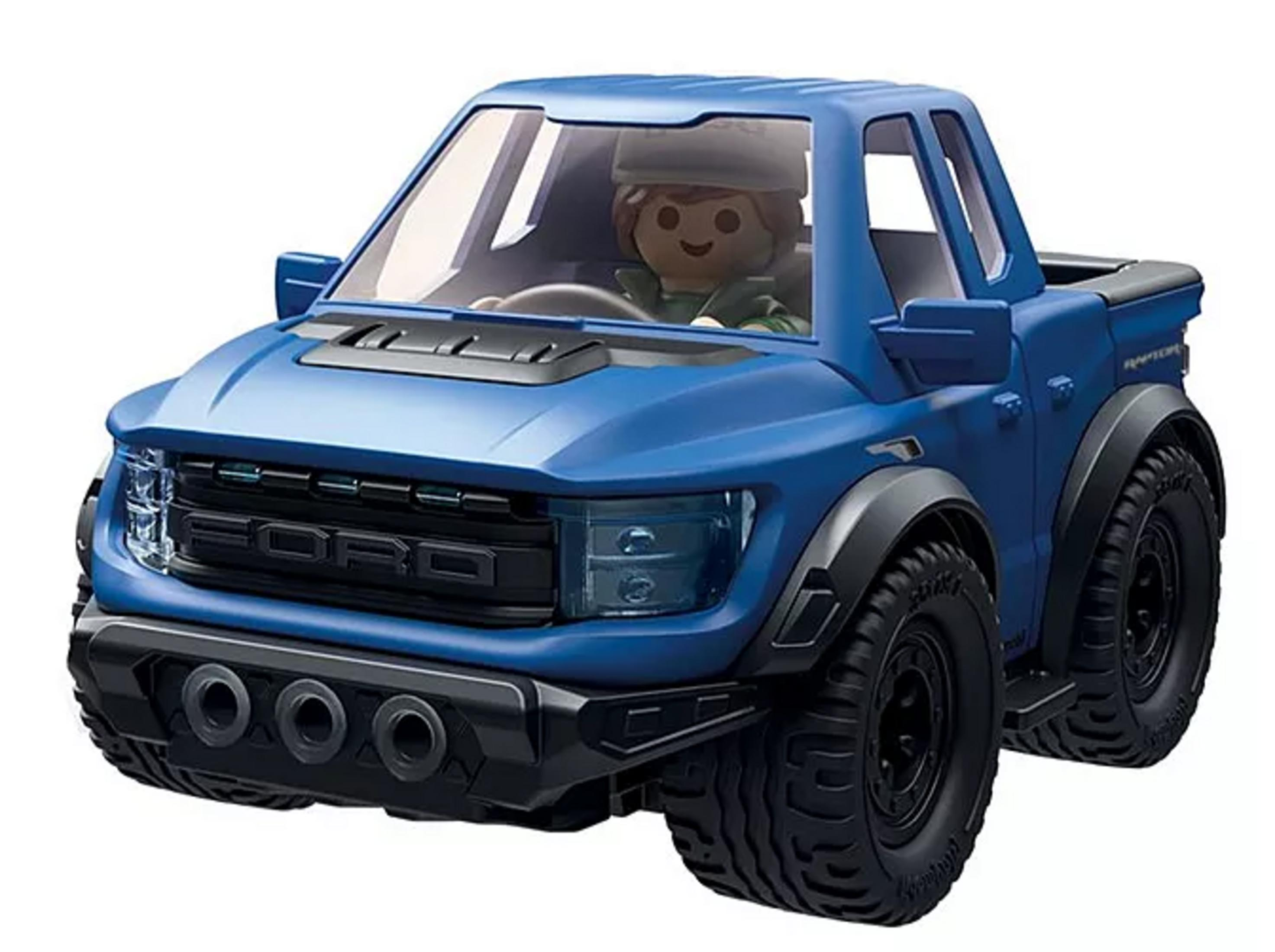Una camioneta pickup de juguete azul con una figura de Playmobil al volante.