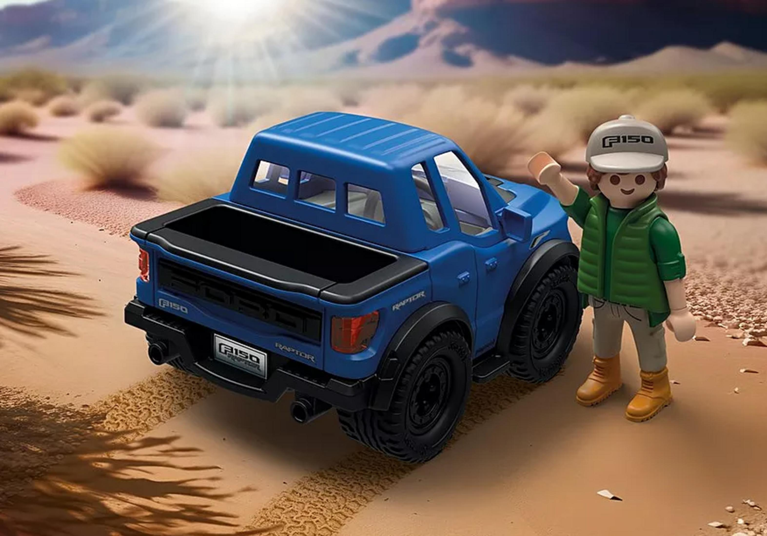 Un juguete de camioneta Ford F150 Raptor azul está en una escena desértica junto a una figura.