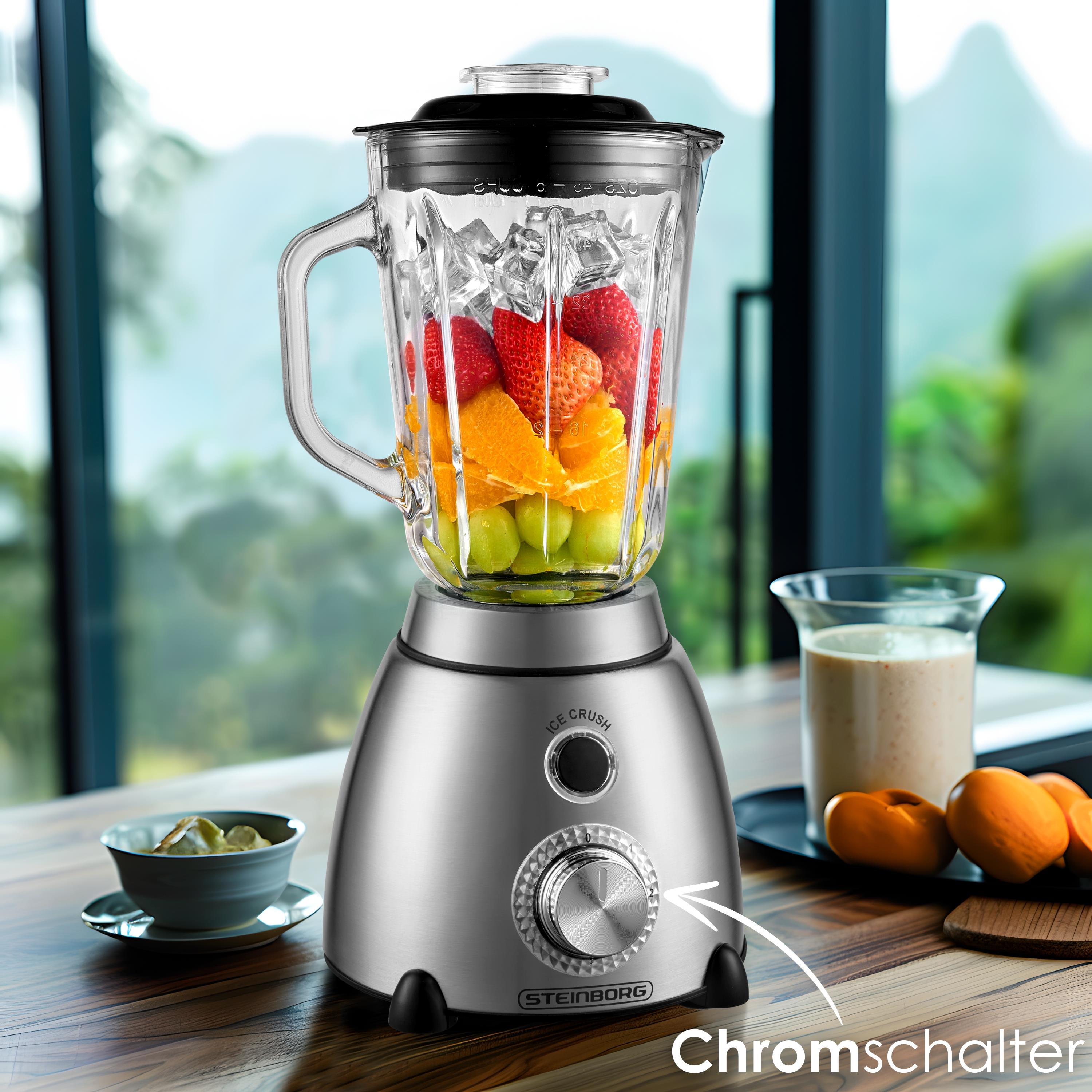 Ein silberner Standmixer mit Früchten und Eis, daneben ein Glas Smoothie.