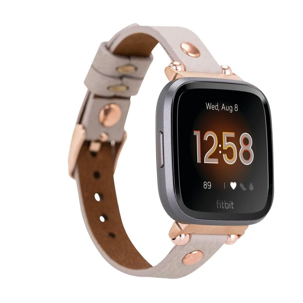 Rose altın vurgulu gri deri kordonlu Fitbit akıllı saat 12:58 gösteriyor.