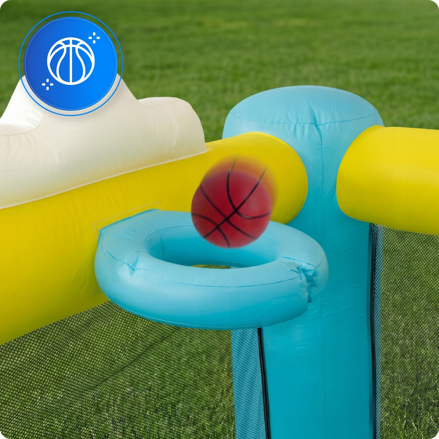 Ein roter Basketball bewegt sich in der Nähe eines blauen aufblasbaren Korbs auf einer gelben und weißen Hüpfburg.