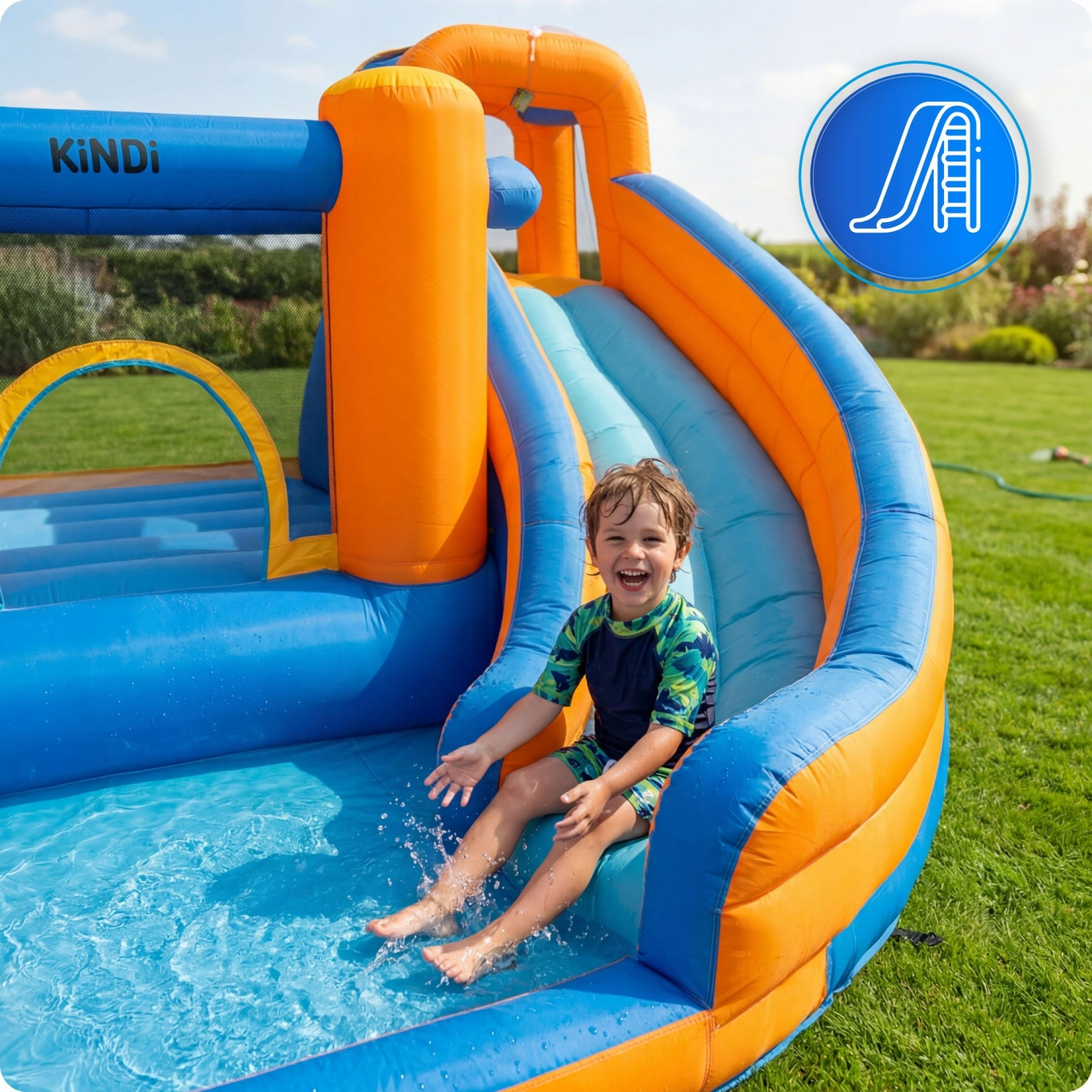 Ein Junge rutscht lachend auf einer bunten Wasserrutsche in einen Pool.