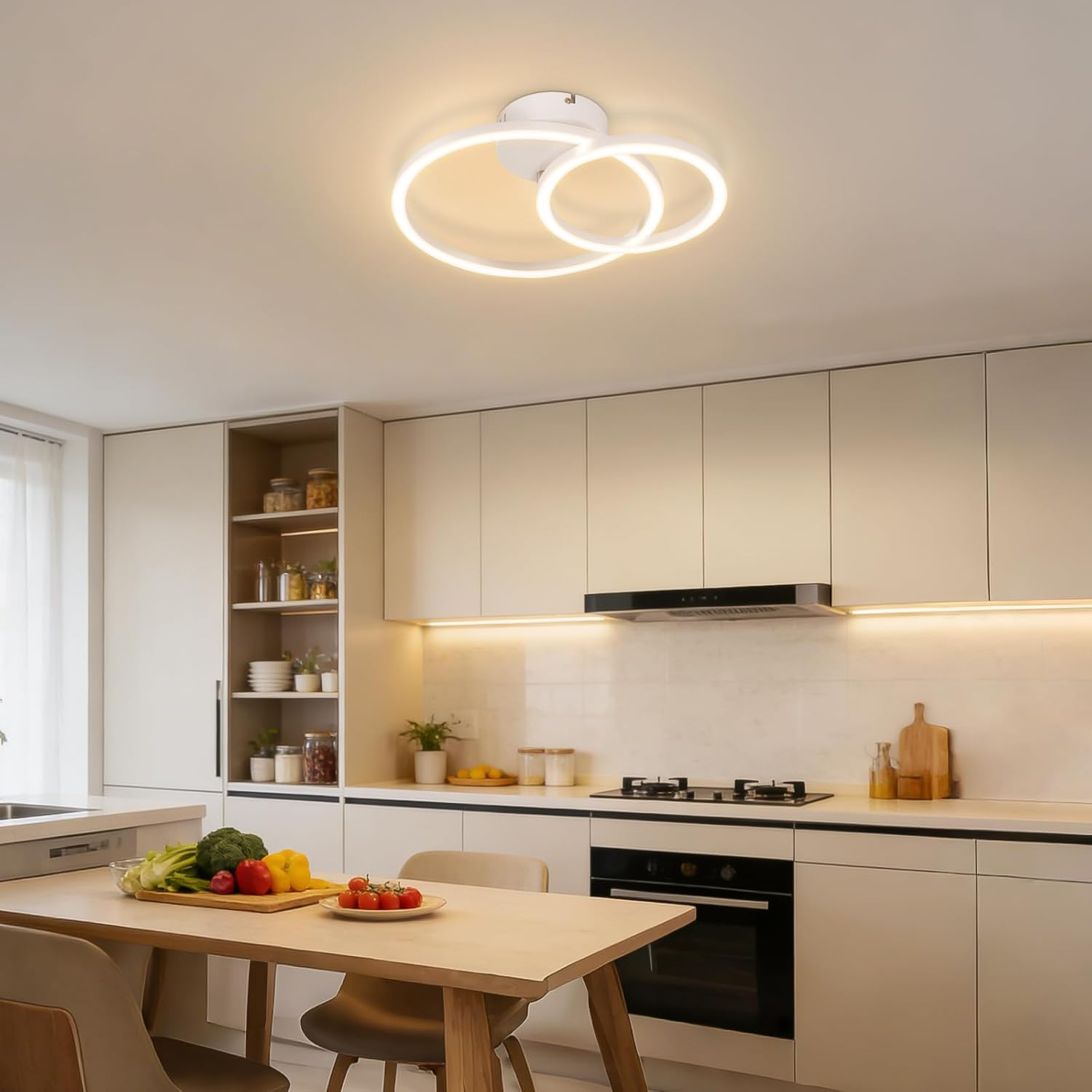 Cucina moderna con zona pranzo, fornelli e lampada a sospensione.
