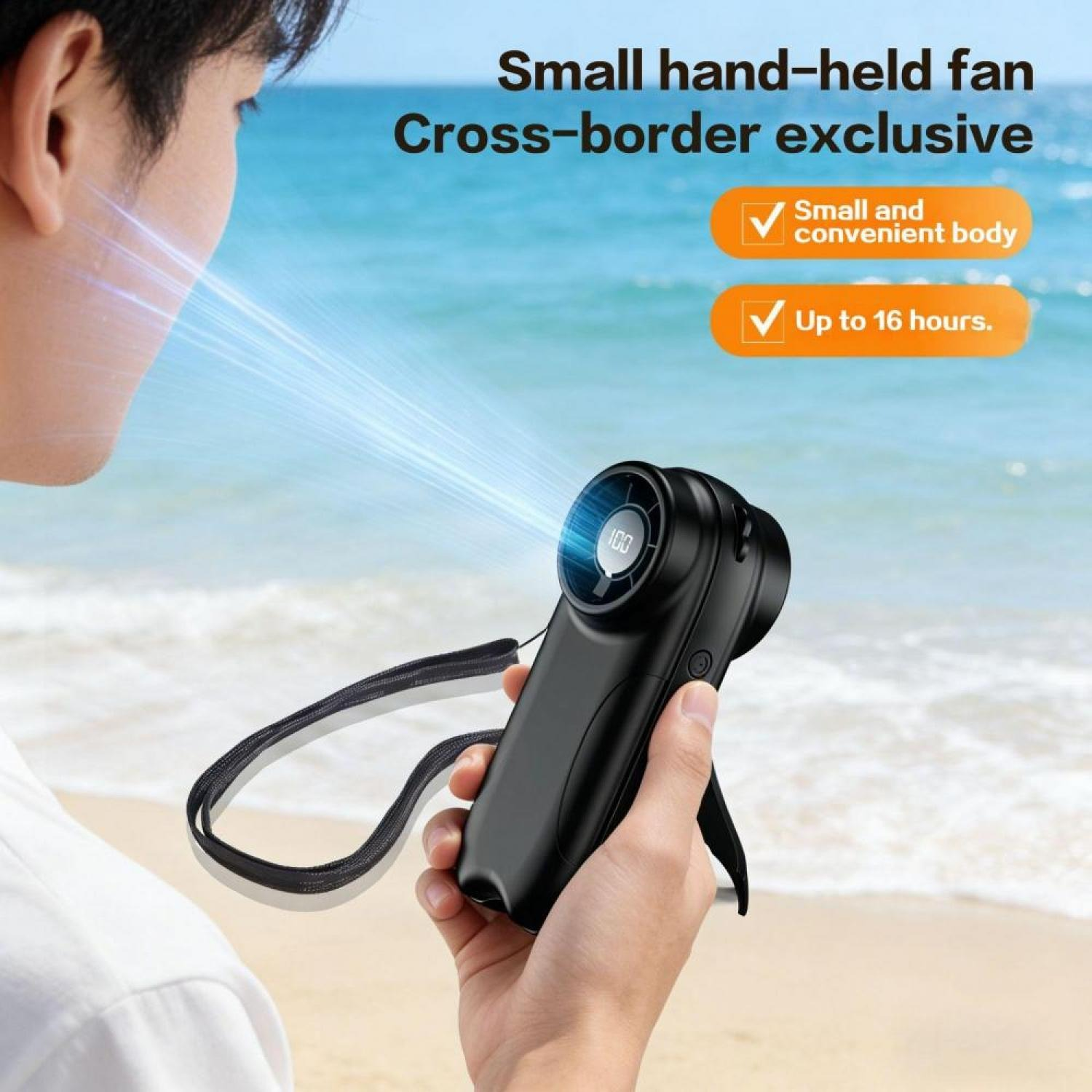 Ein Mann hält einen schwarzen Handventilator am Strand. Luftstrom wird auf sein Gesicht gerichtet.