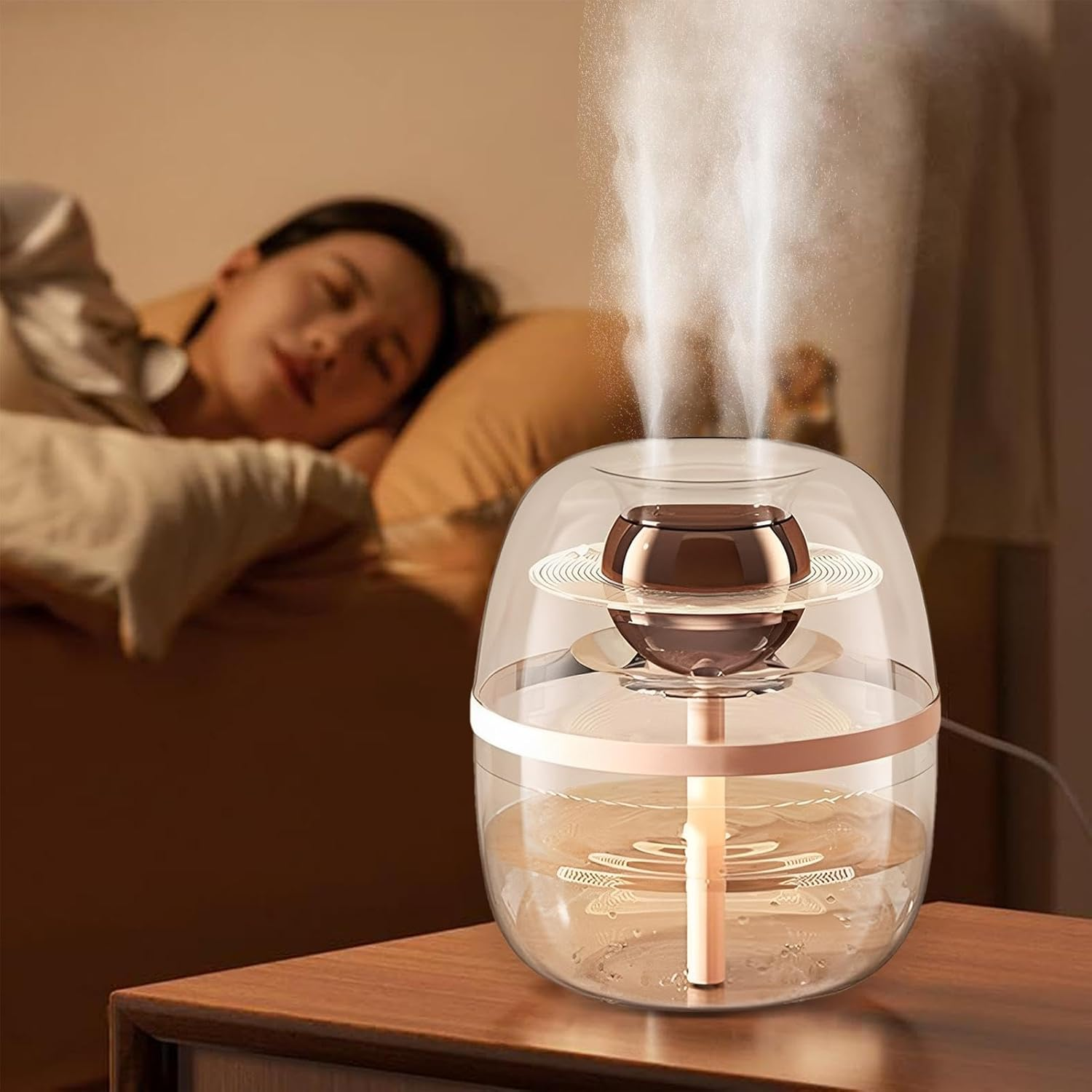 Eine Frau schläft im Bett, während ein klarer Luftbefeuchter mit Wasser Nebel abgibt.