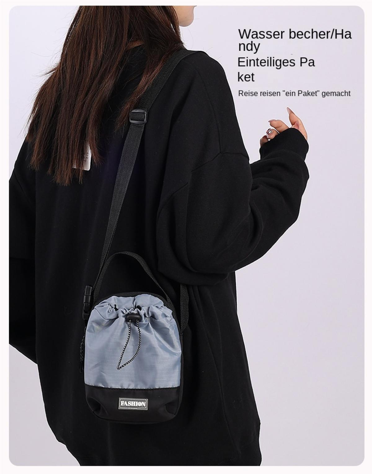 Eine Person trägt eine graue und schwarze Tasche mit der Aufschrift "FASHION".