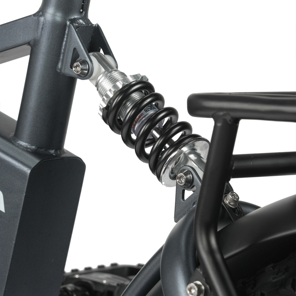 Zbliżenie amortyzatora rowerowego z czarną sprężyną i srebrnymi detalami.