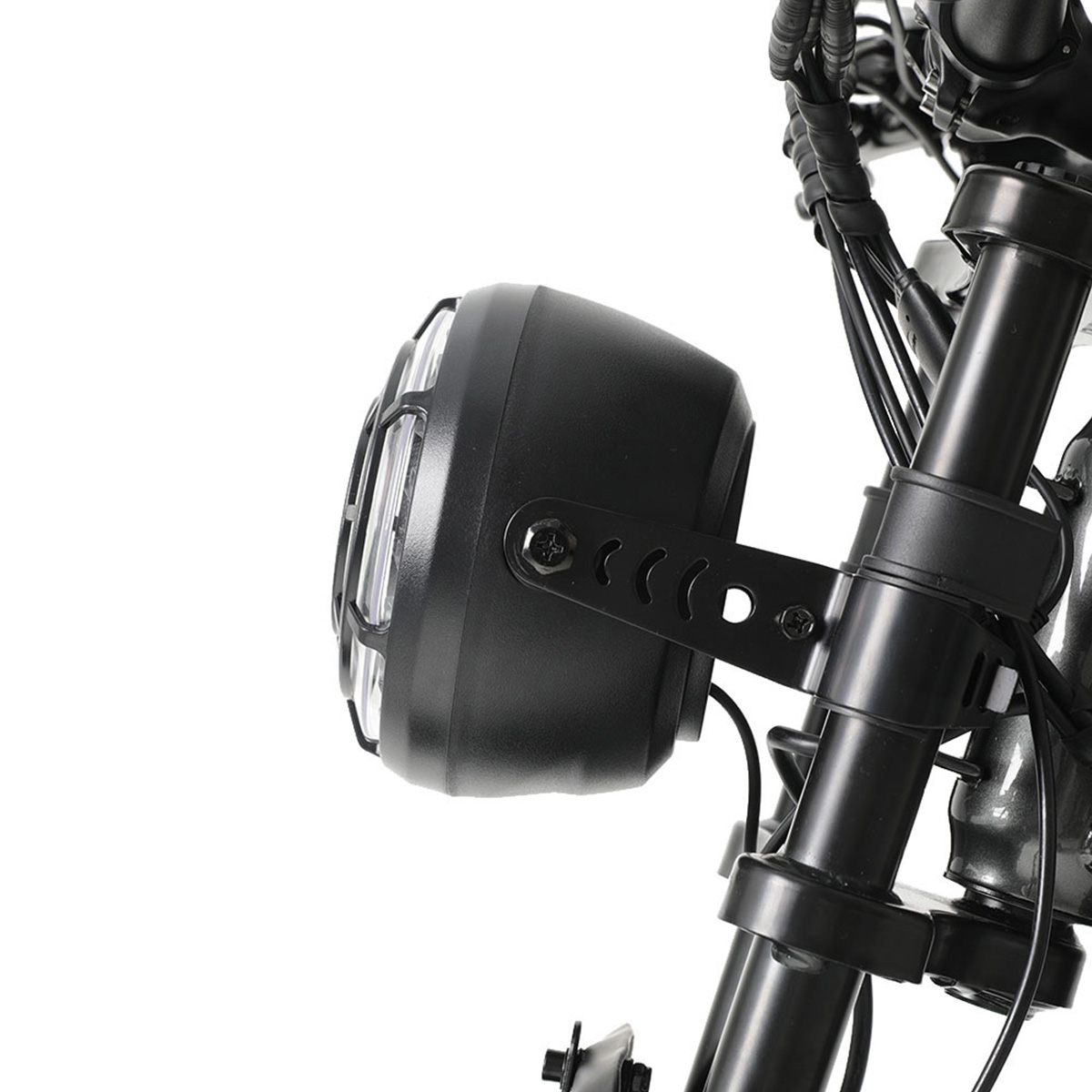 Czarny reflektor motocyklowy z kratką ochronną i mocowaniem.