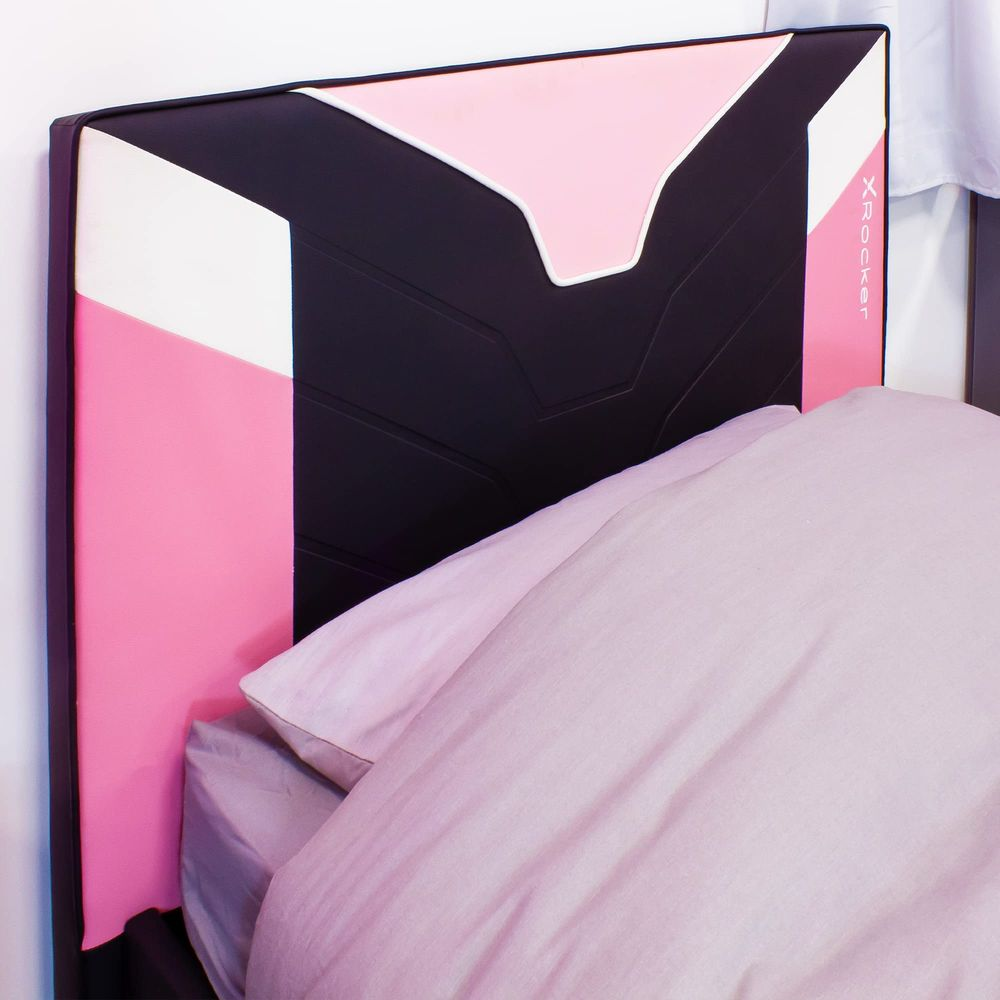 Una testiera nera e rosa con accenti bianchi sopra un letto con biancheria da letto rosa.