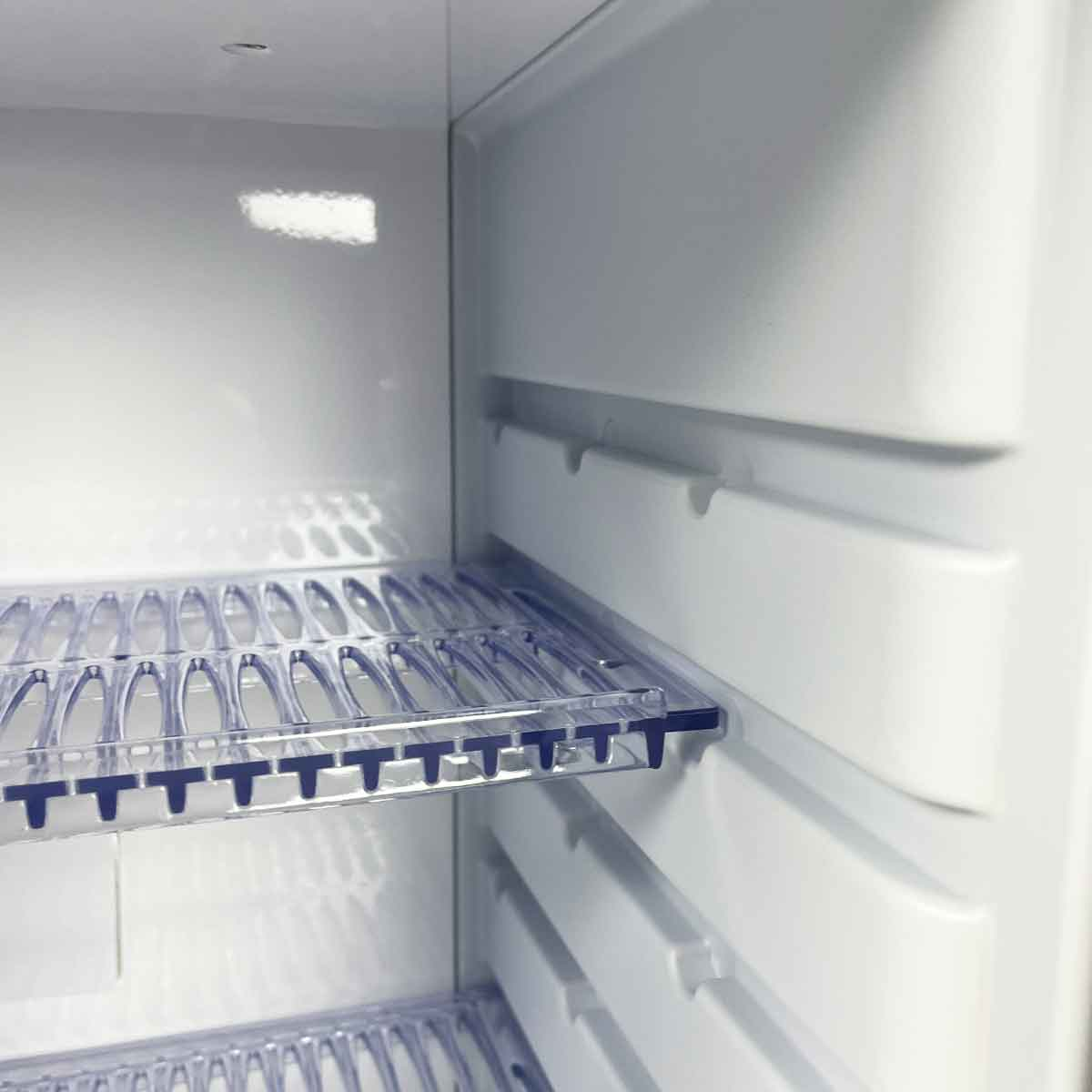Empty white refrigerator shelves with clear inserts and blue clips.