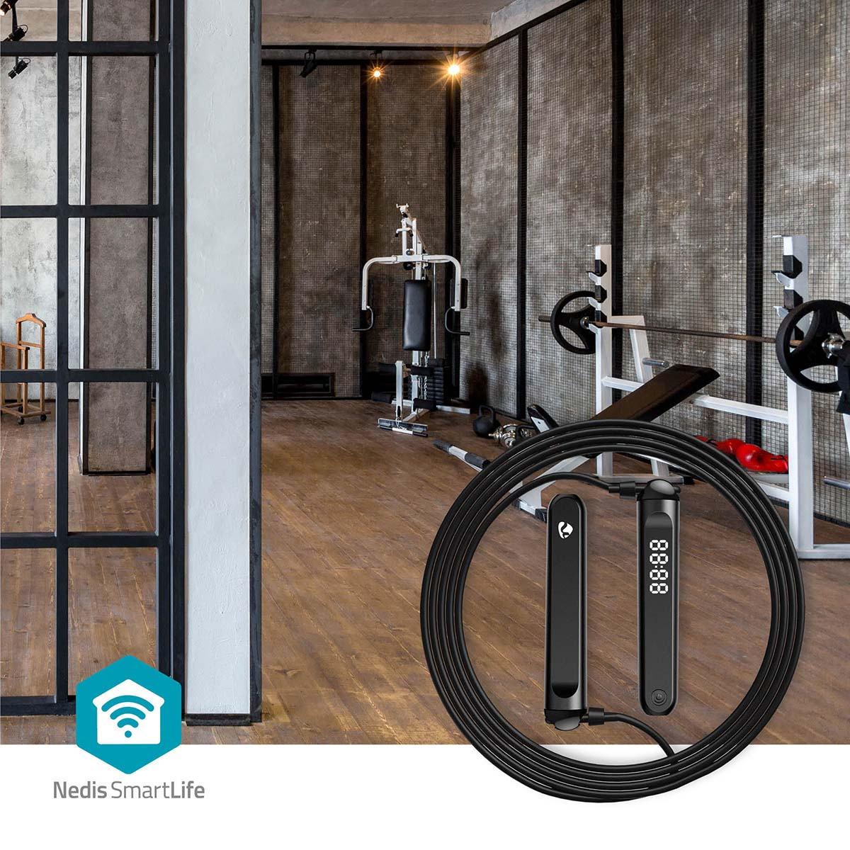 A black jump rope with digital handles lies in front of a gym with equipment.