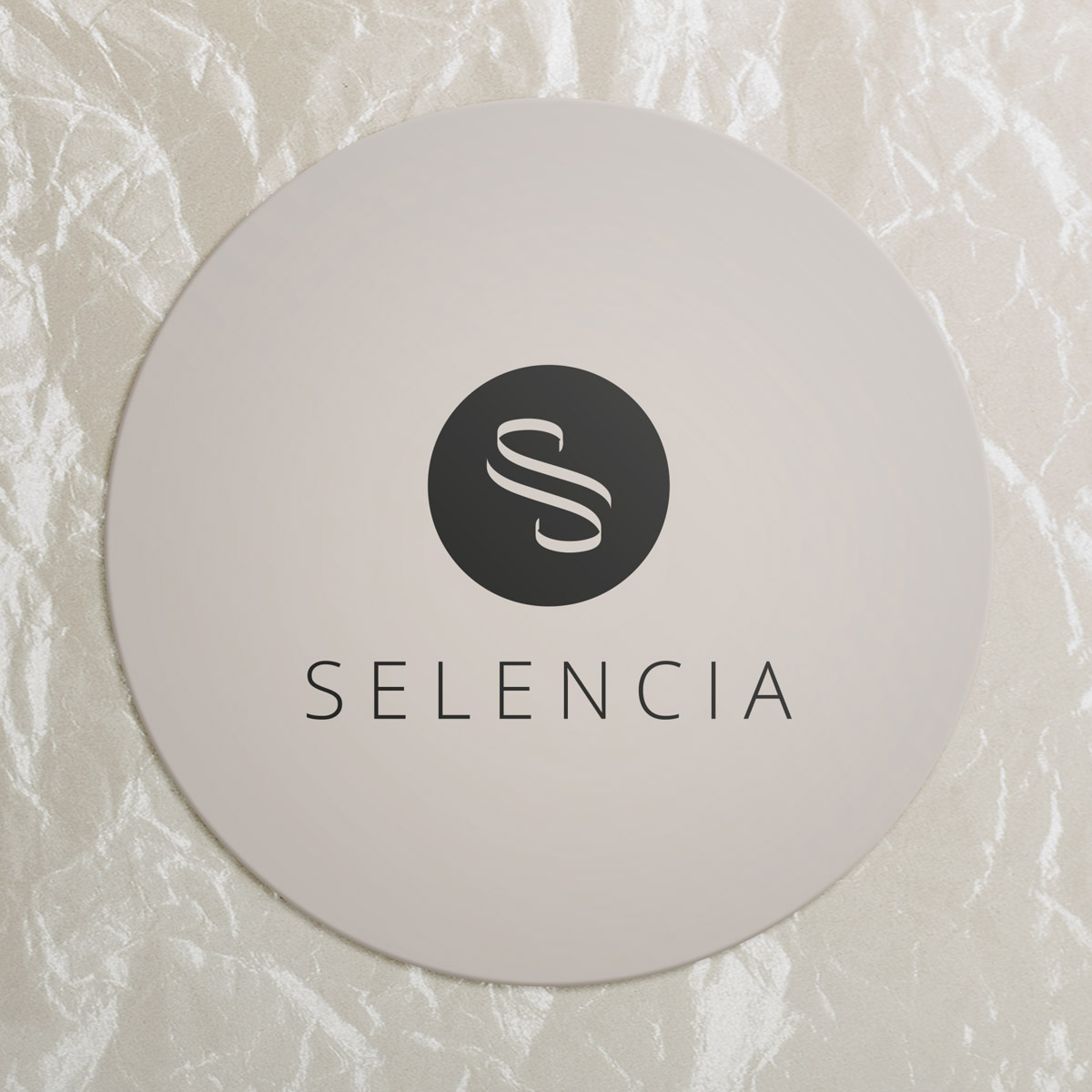 A beige circle with the text SELENCIA and a stylized S logo on a light background.