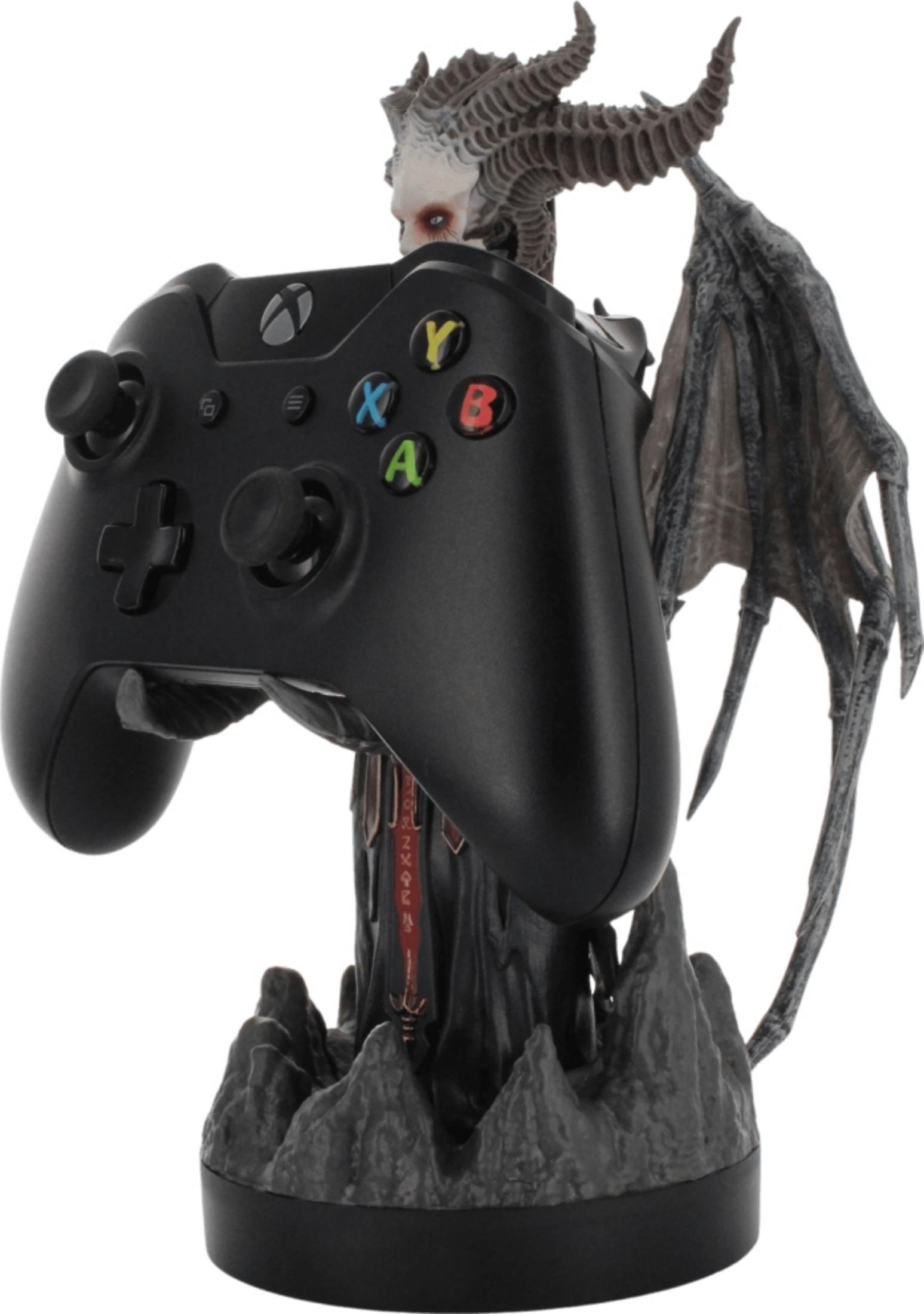 Figurine de démon tenant une manette Xbox sur socle rocheux.