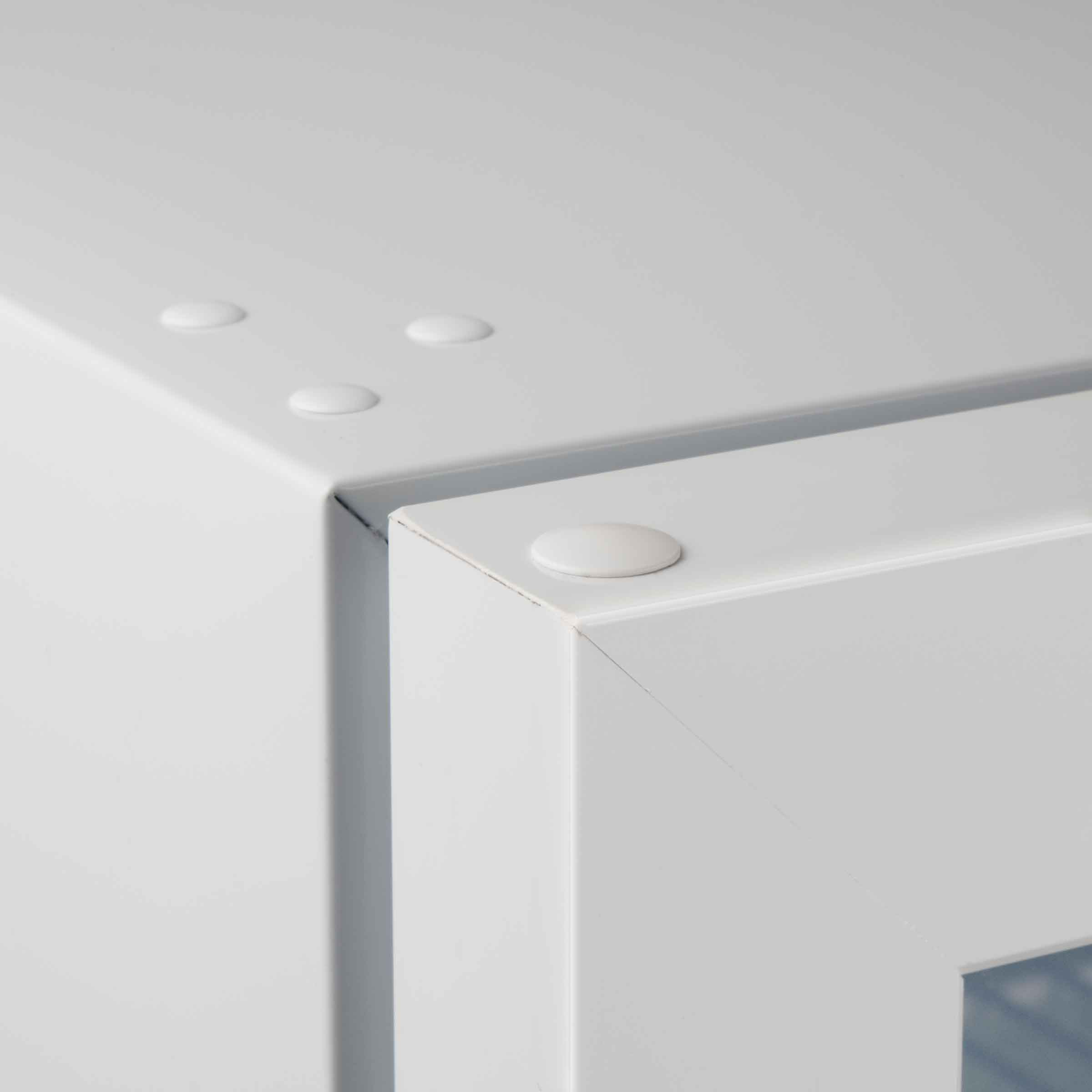 Witte kast hoek met ronde knoppen en lichte krasjes.