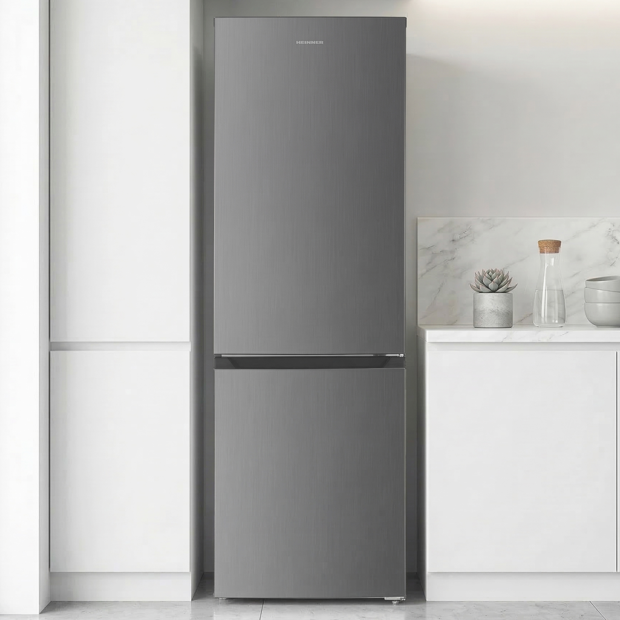 Een grijze koelkast met twee deuren staat in een moderne keuken naast witte kasten.
