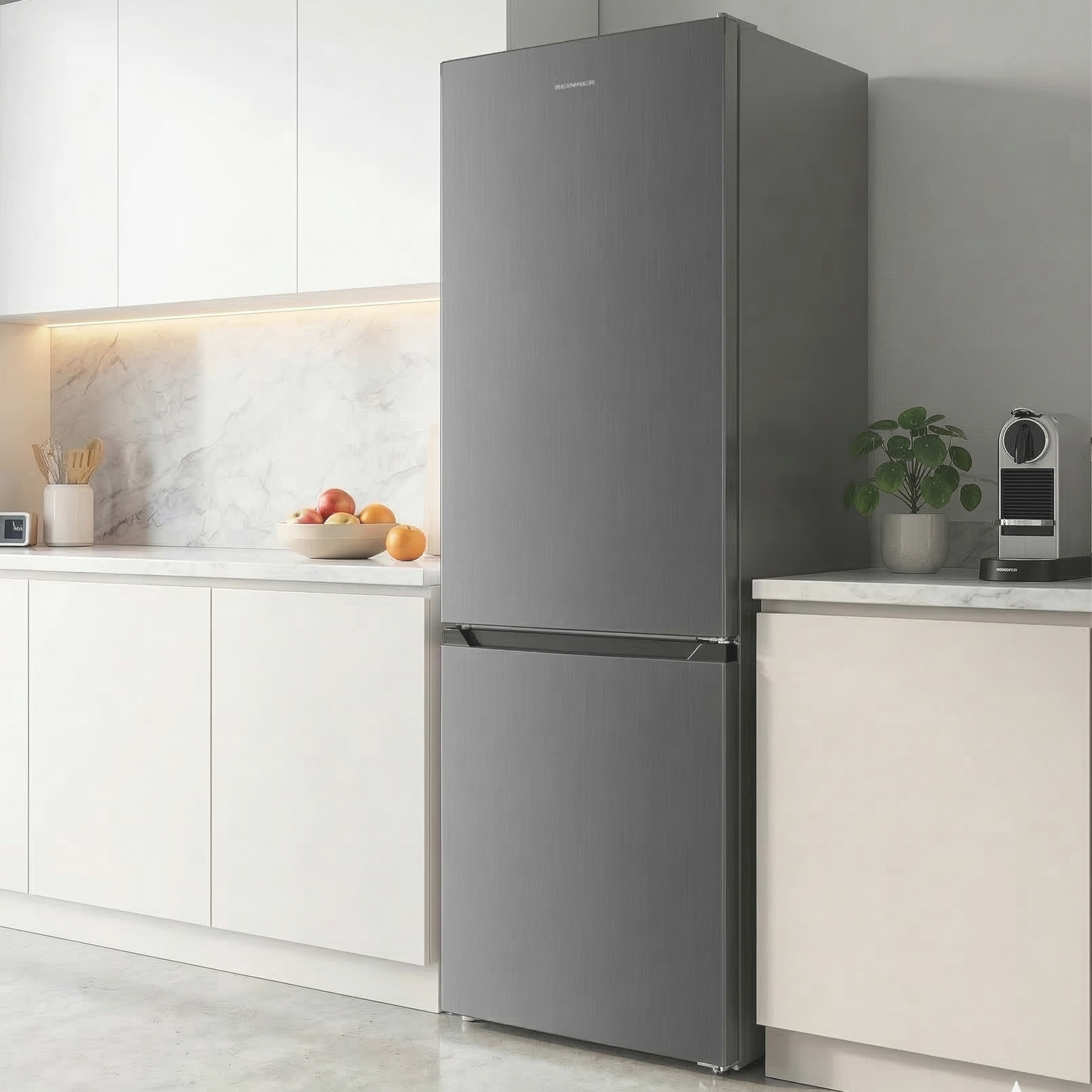 Een moderne grijze koelkast in een stijlvolle keuken naast witte kasten en een marmeren achterwand.