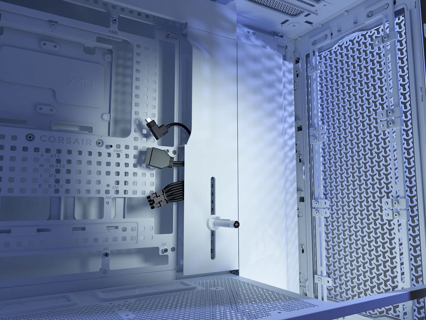 Wnętrze białej obudowy komputera z kablami i perforowanymi panelami.