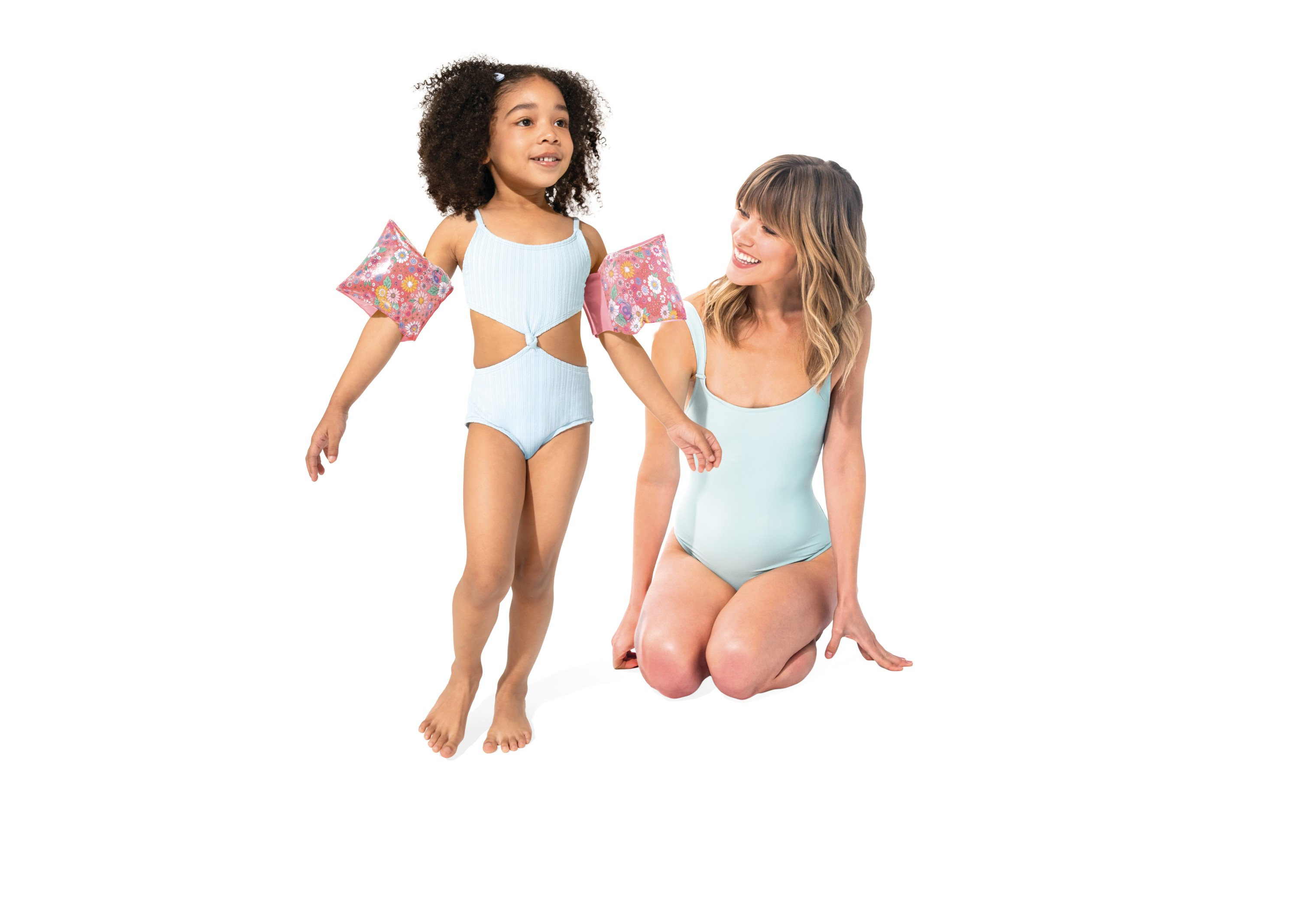 Kobieta i dziewczynka w strojach kąpielowych na białym tle.