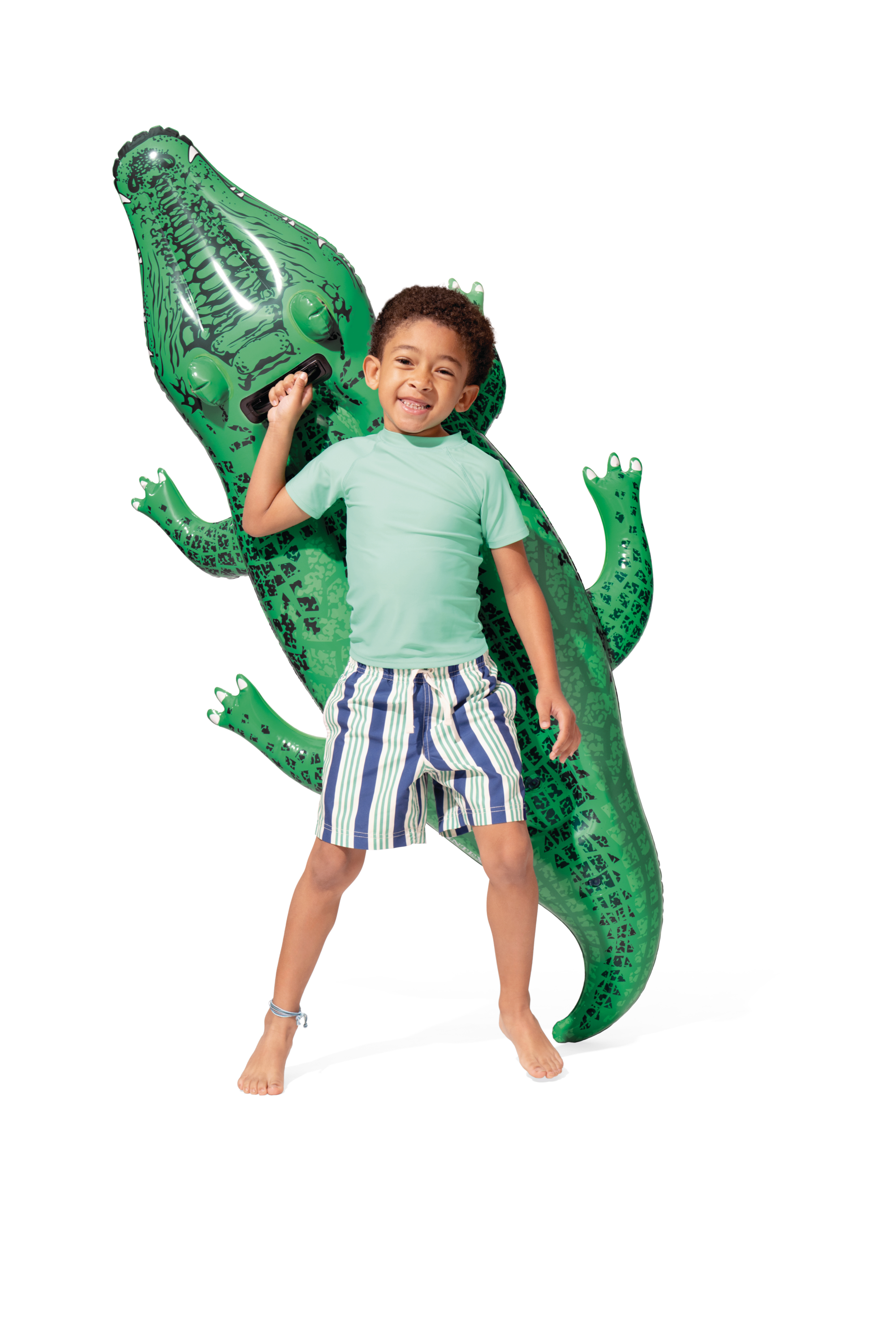 Chłopiec stoi z dmuchanym aligatorem na białym tle.