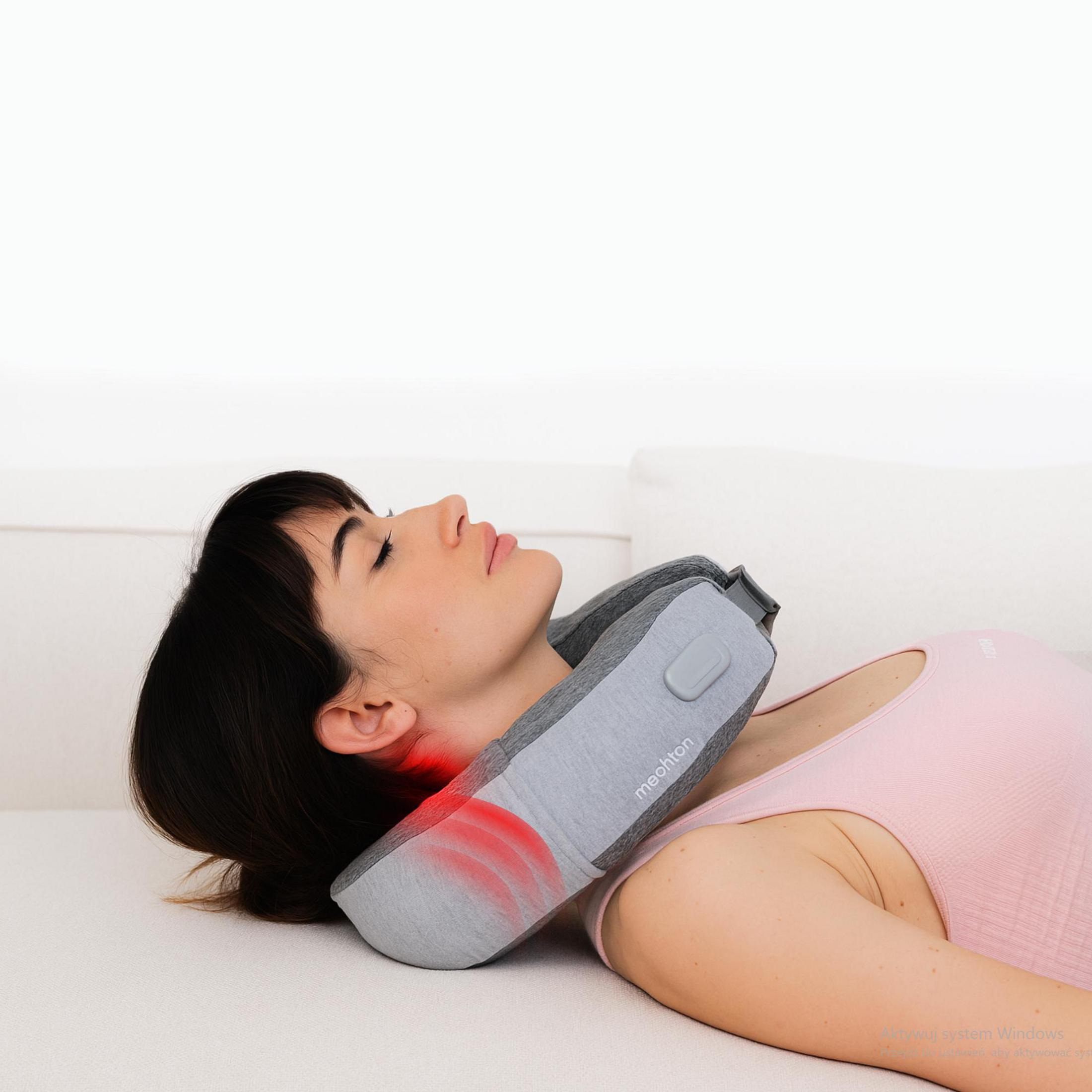 Eine Frau liegt auf einem Sofa mit einem Nackenmassagegerät. Rote Lichter zeigen Massagezonen.