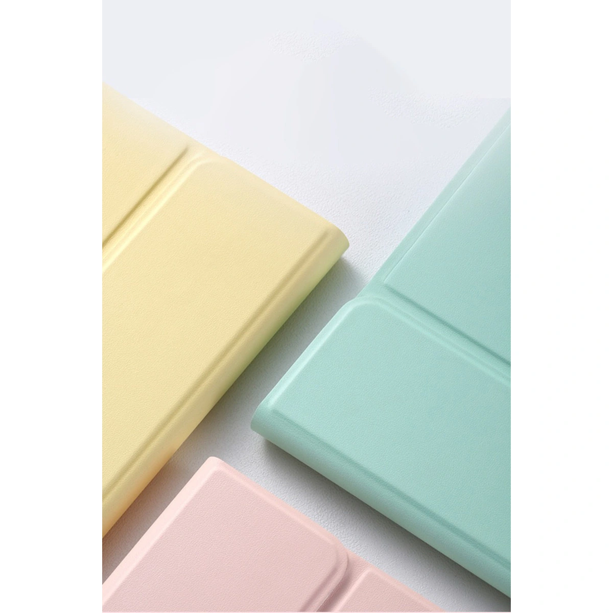 Üç pastel renkli tablet kılıfı: sarı, nane yeşili ve pembe.