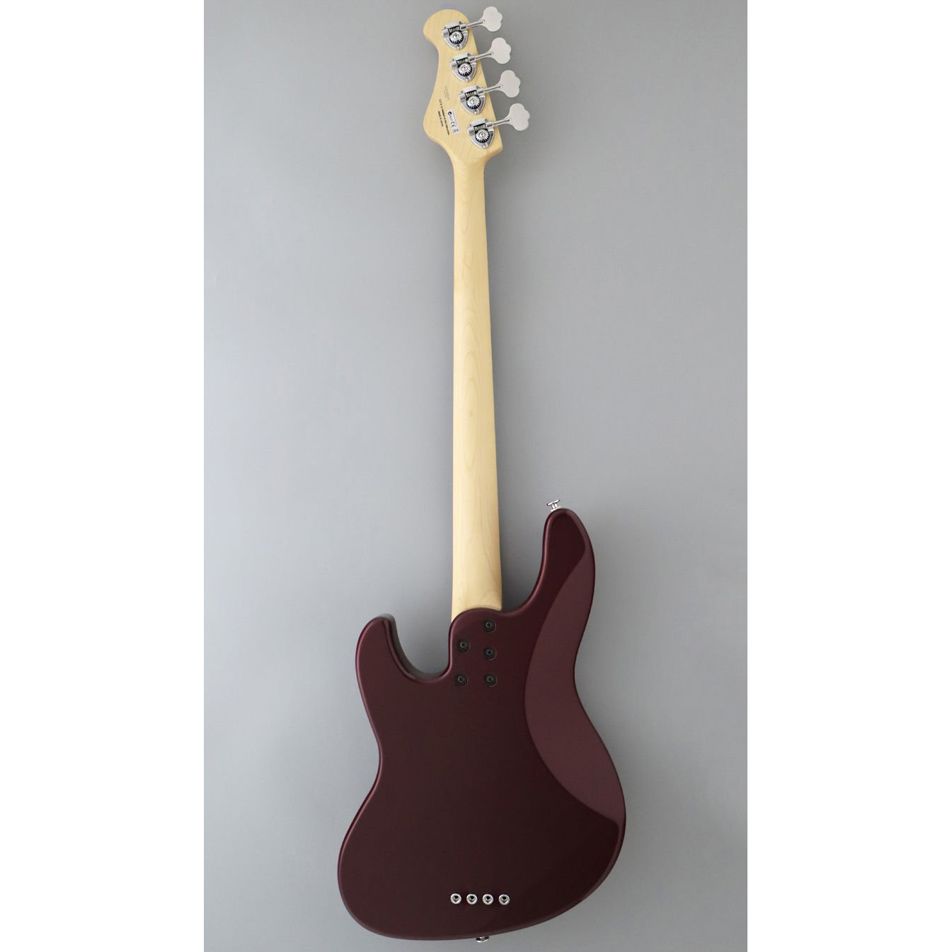 Açık ahşap sapa ve dört tele sahip koyu kırmızı bas gitarın arka görünümü.