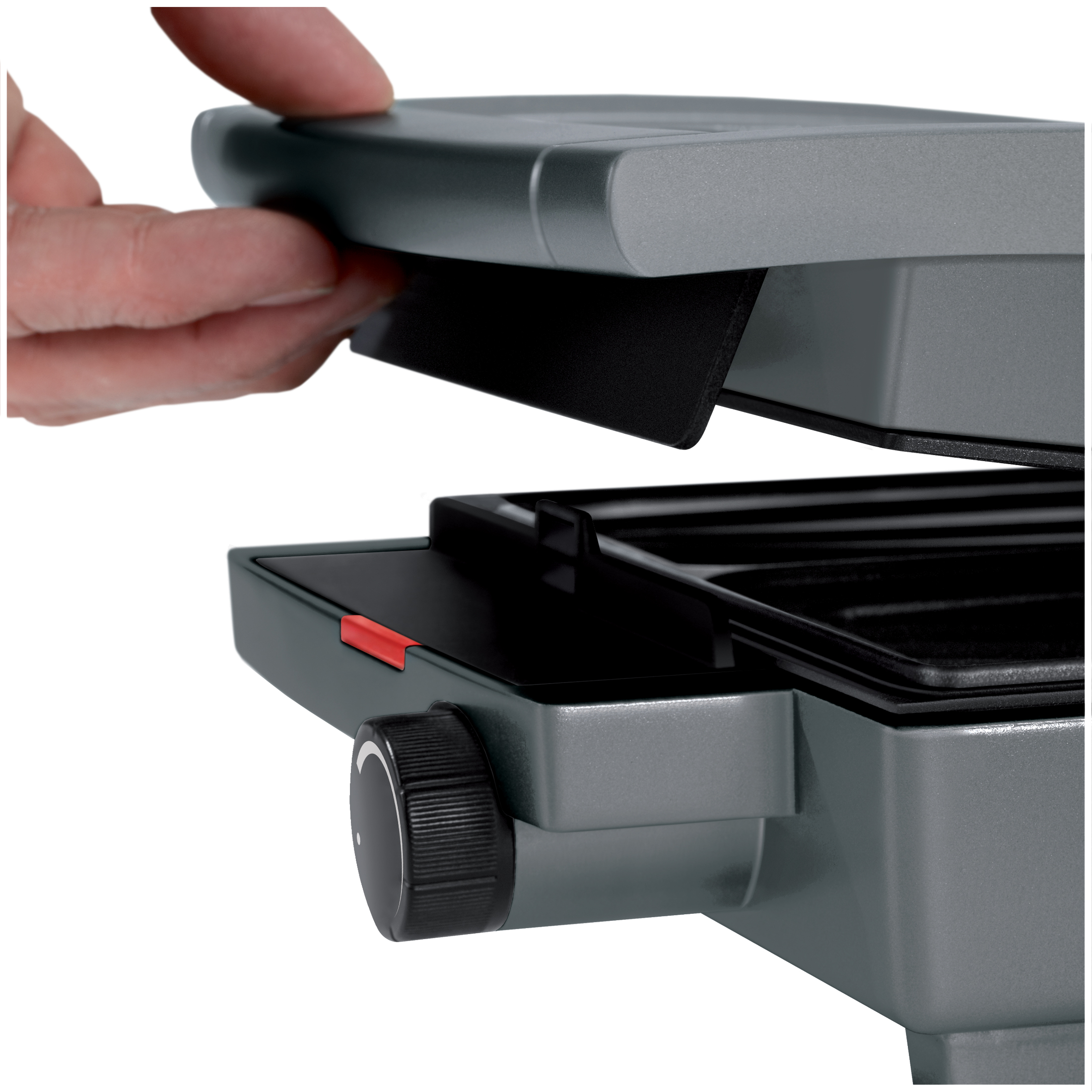 A hand opens a gray contact grill with a black handle and a red lever.