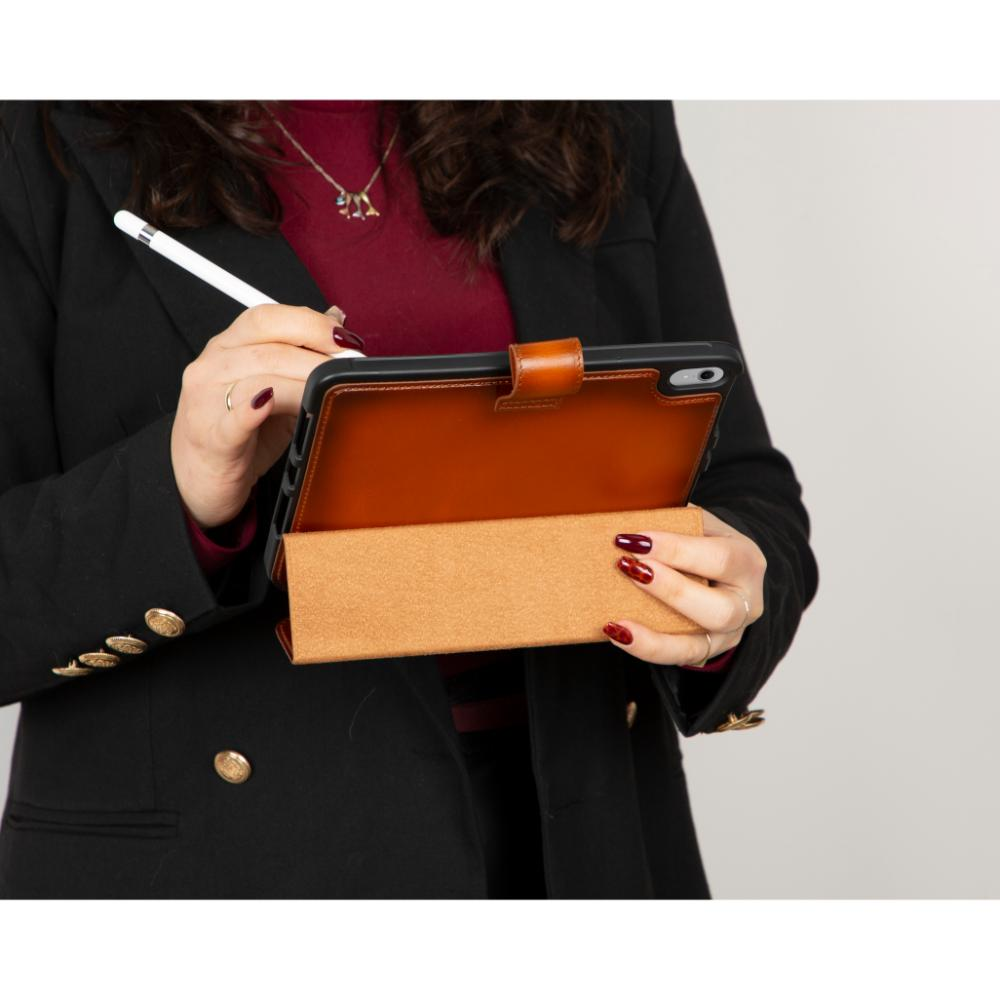 Siyah blazer ve bordo üst giymiş bir kadın tablet üzerinde kalem kullanıyor.